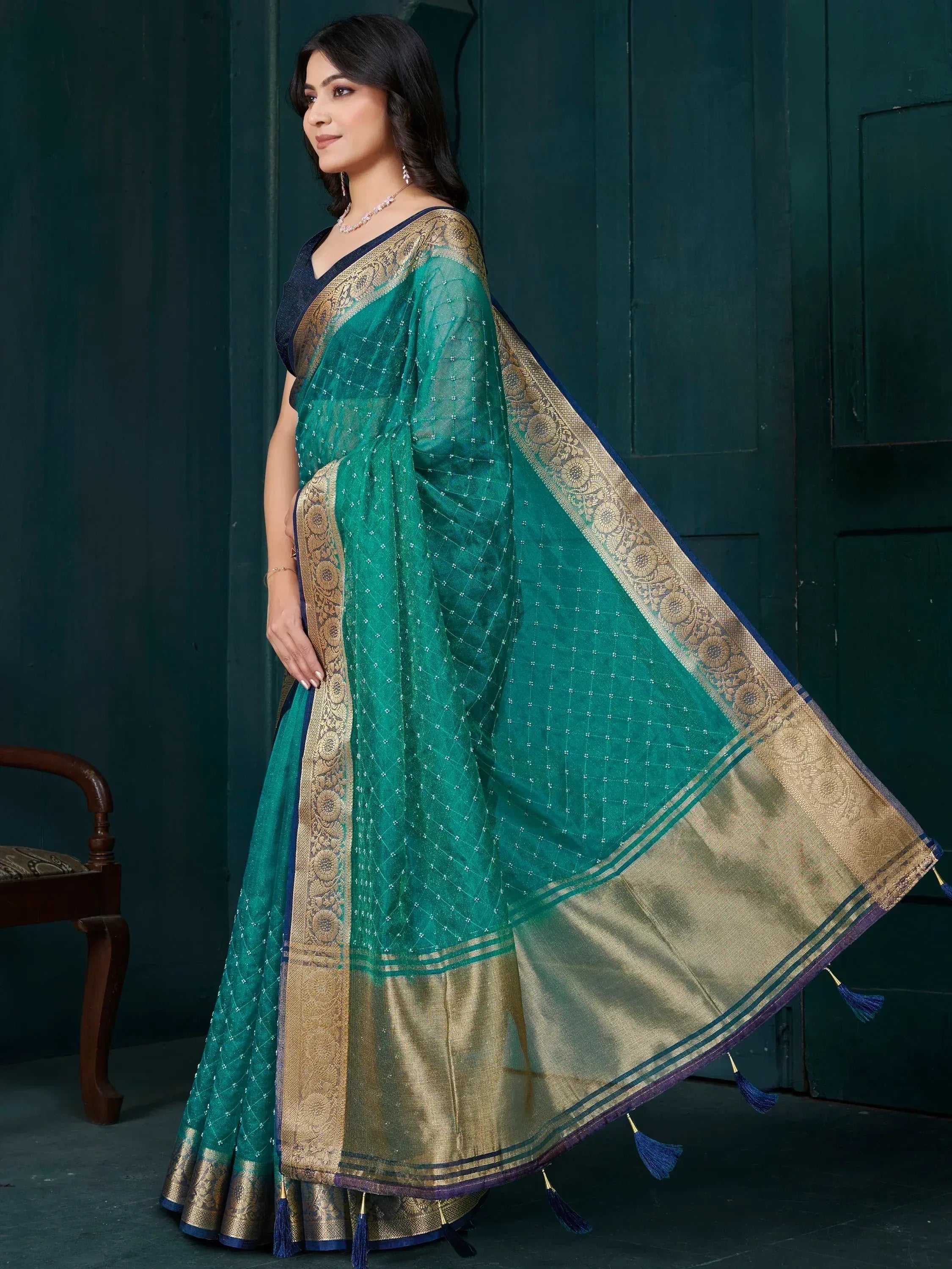 Emerald green saree with gold border and tassels, perfect for ethnic occasions