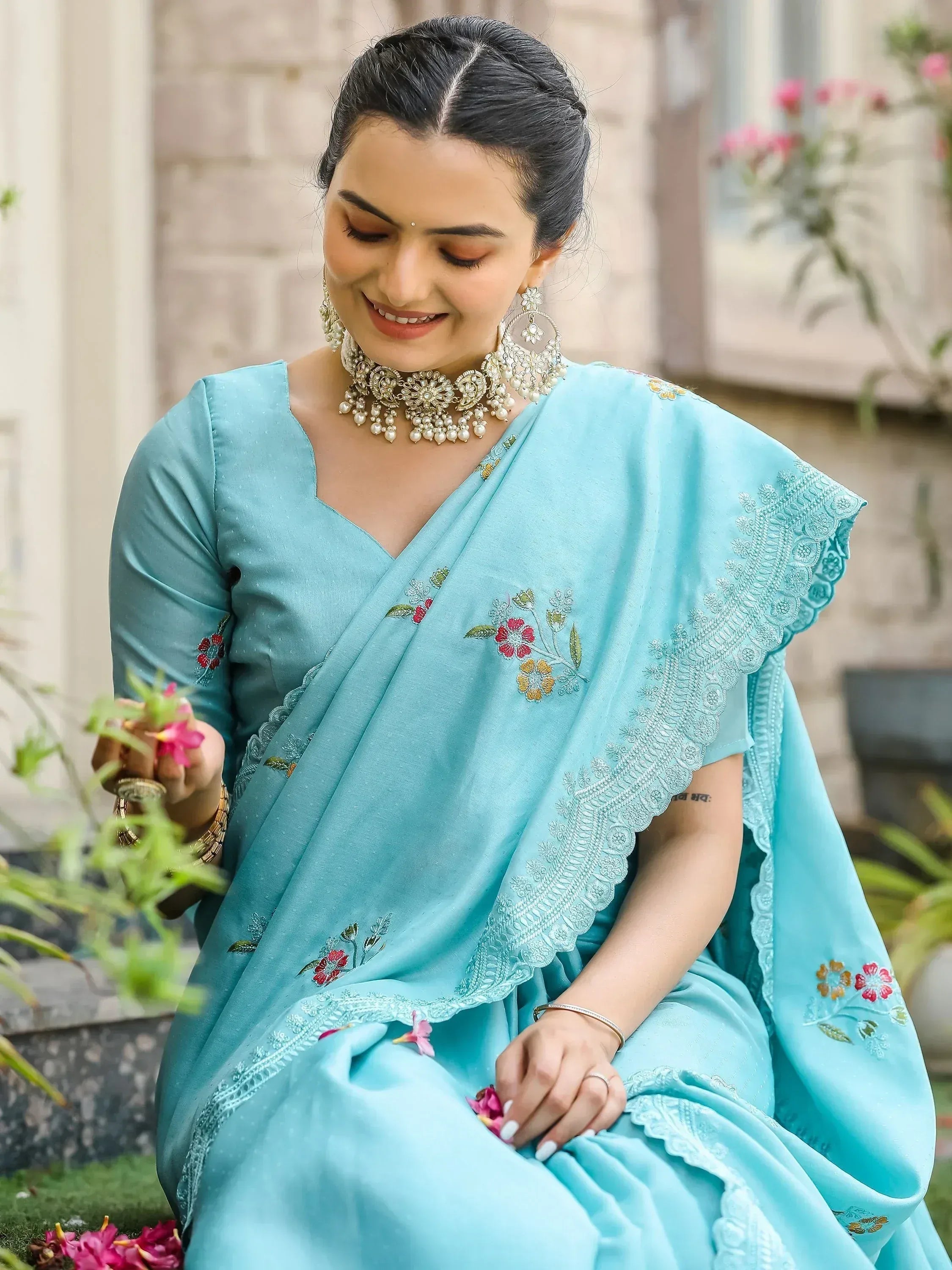 Woman in light blue embroidered saree with floral details, traditional Indian ethnic wear