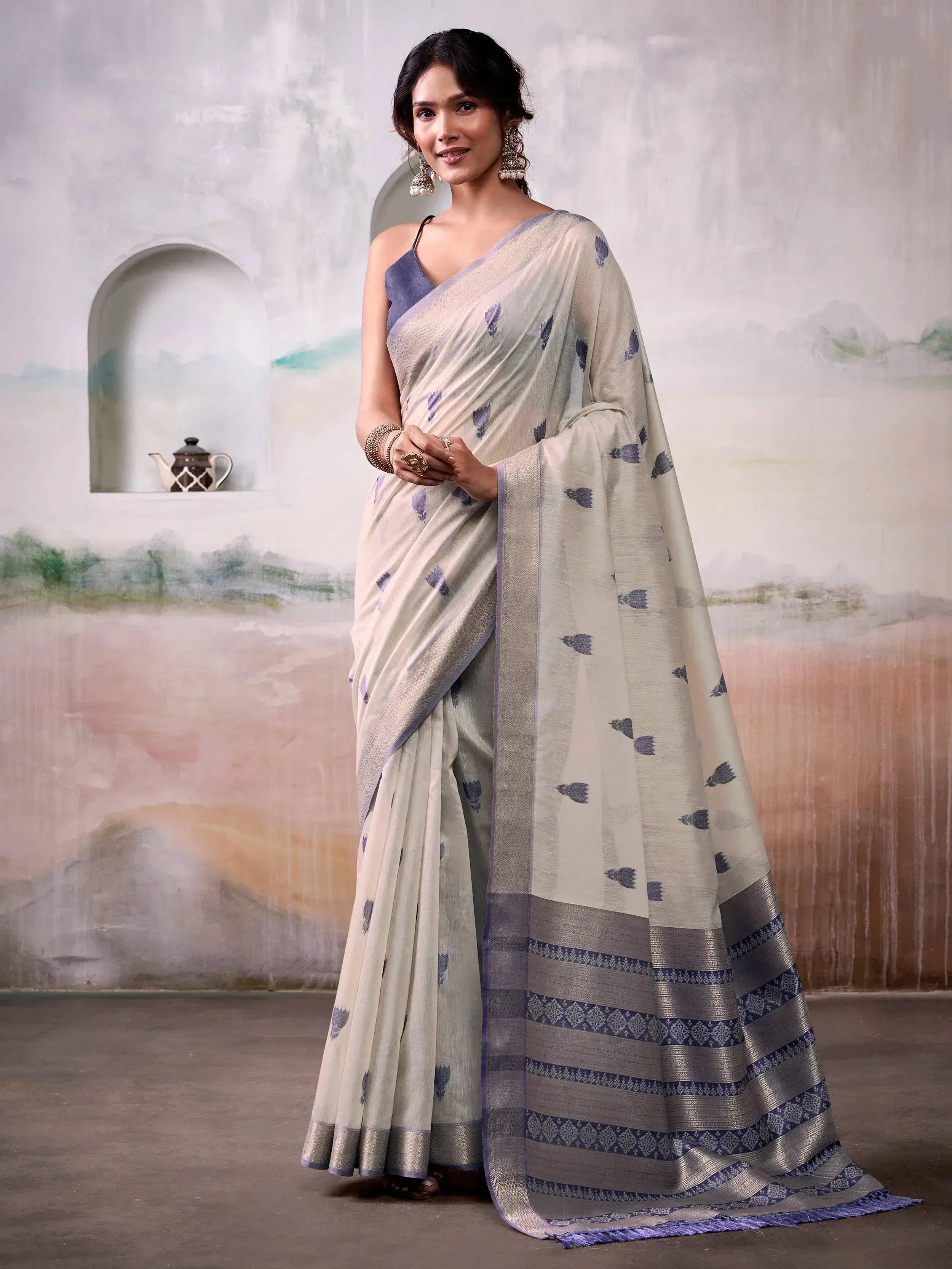 Elegant cream saree with blue floral print and woven border, paired with matching blouse for Indian ethnic wear