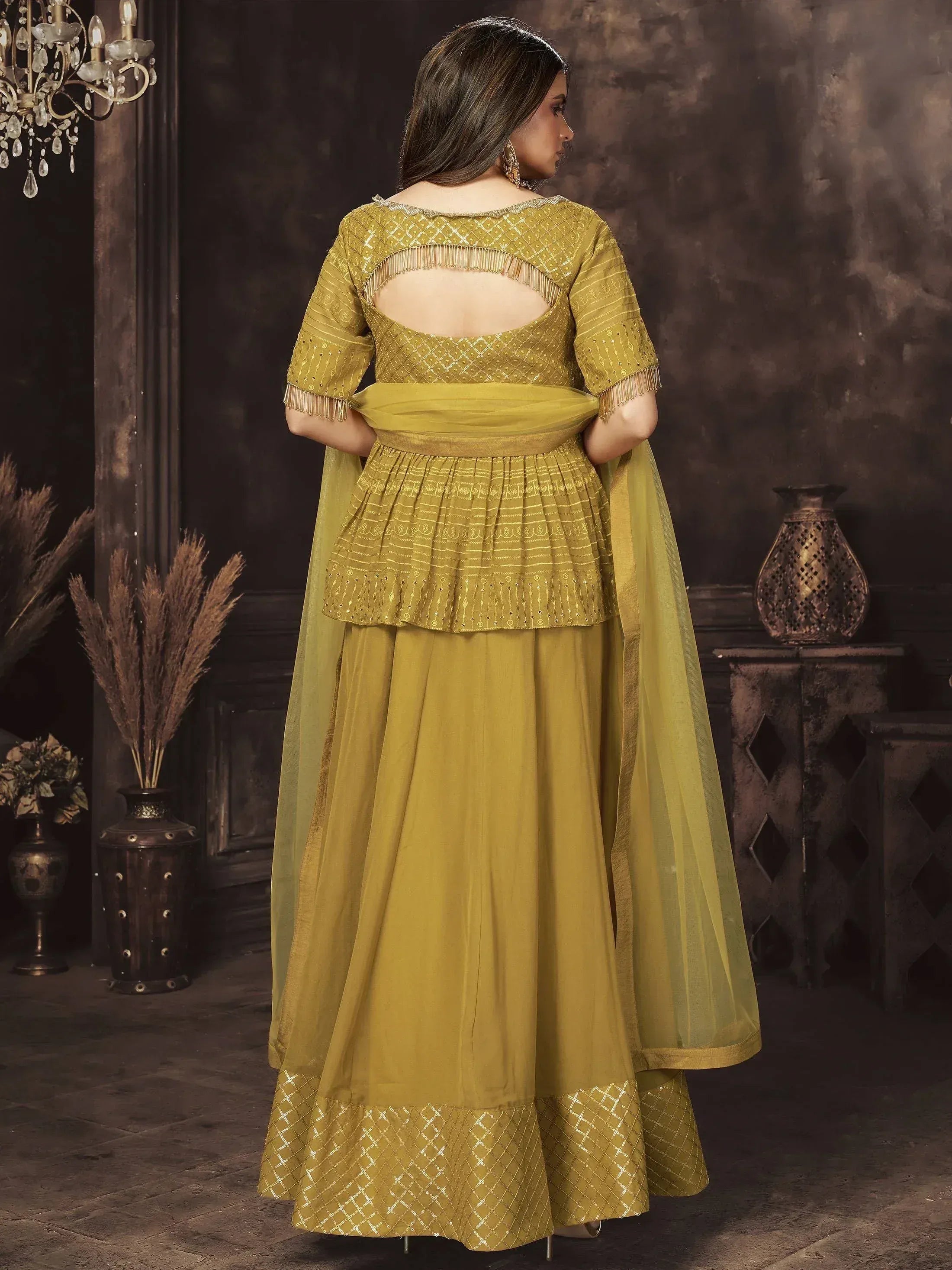 Mustard yellow designer lehenga choli with back cutout, fringes, and gold embroidery for Indian ethnic wear