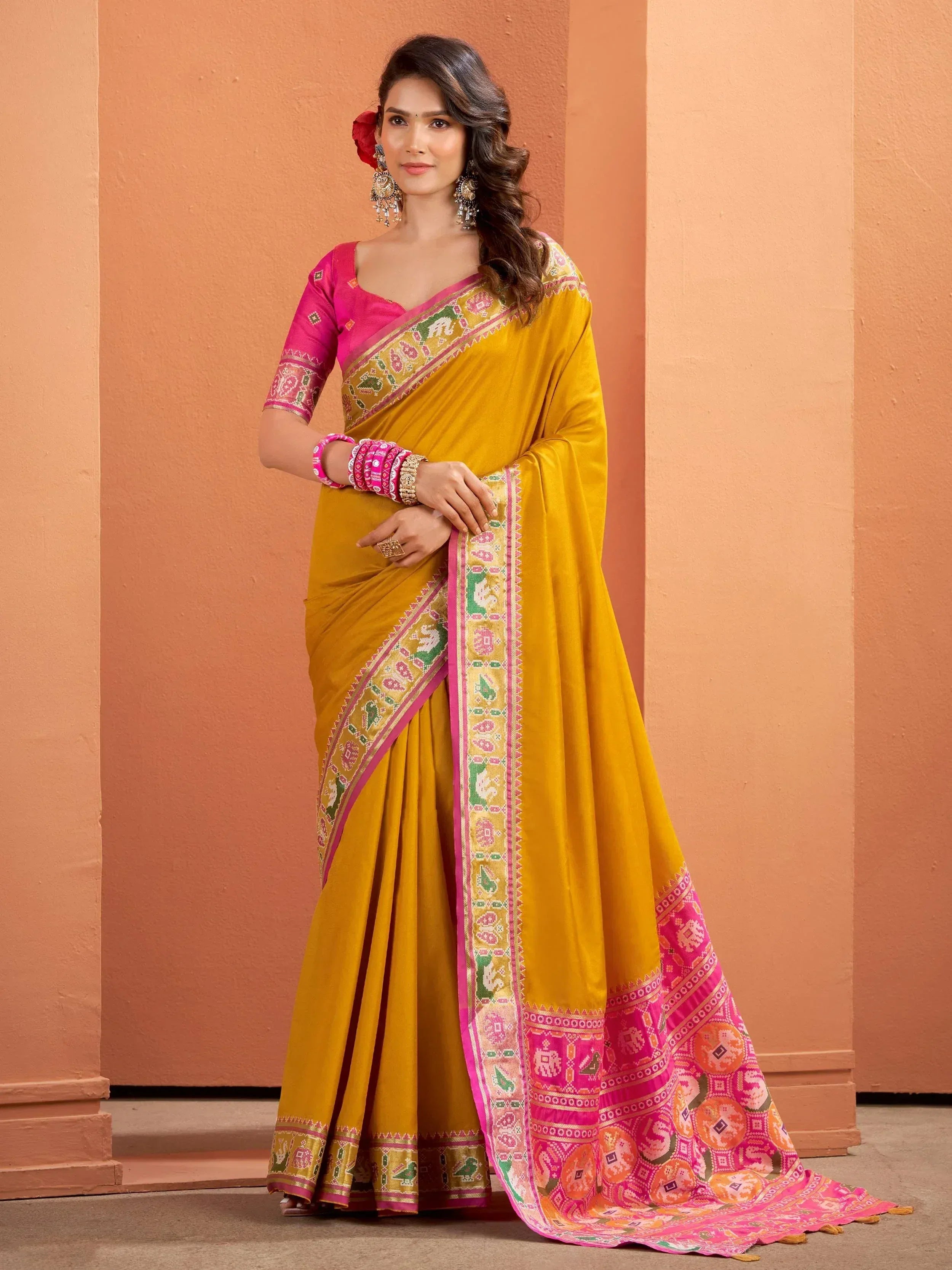 Yellow saree with pink border and elephant print, paired with matching blouse, perfect for Indian ethnic wear
