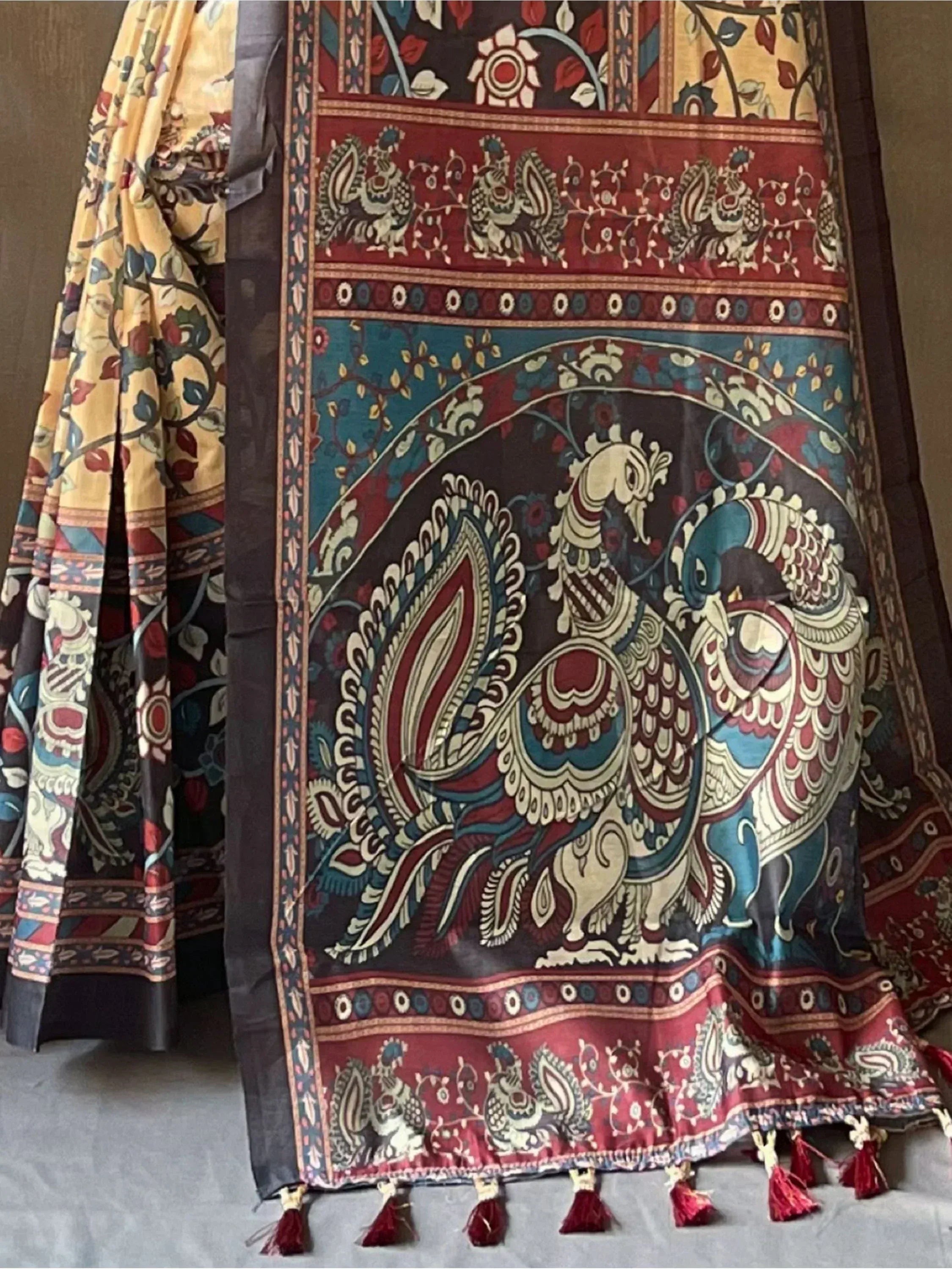 Indian ethnic saree with peacock print, floral motifs, and tassels, perfect for traditional occasions
