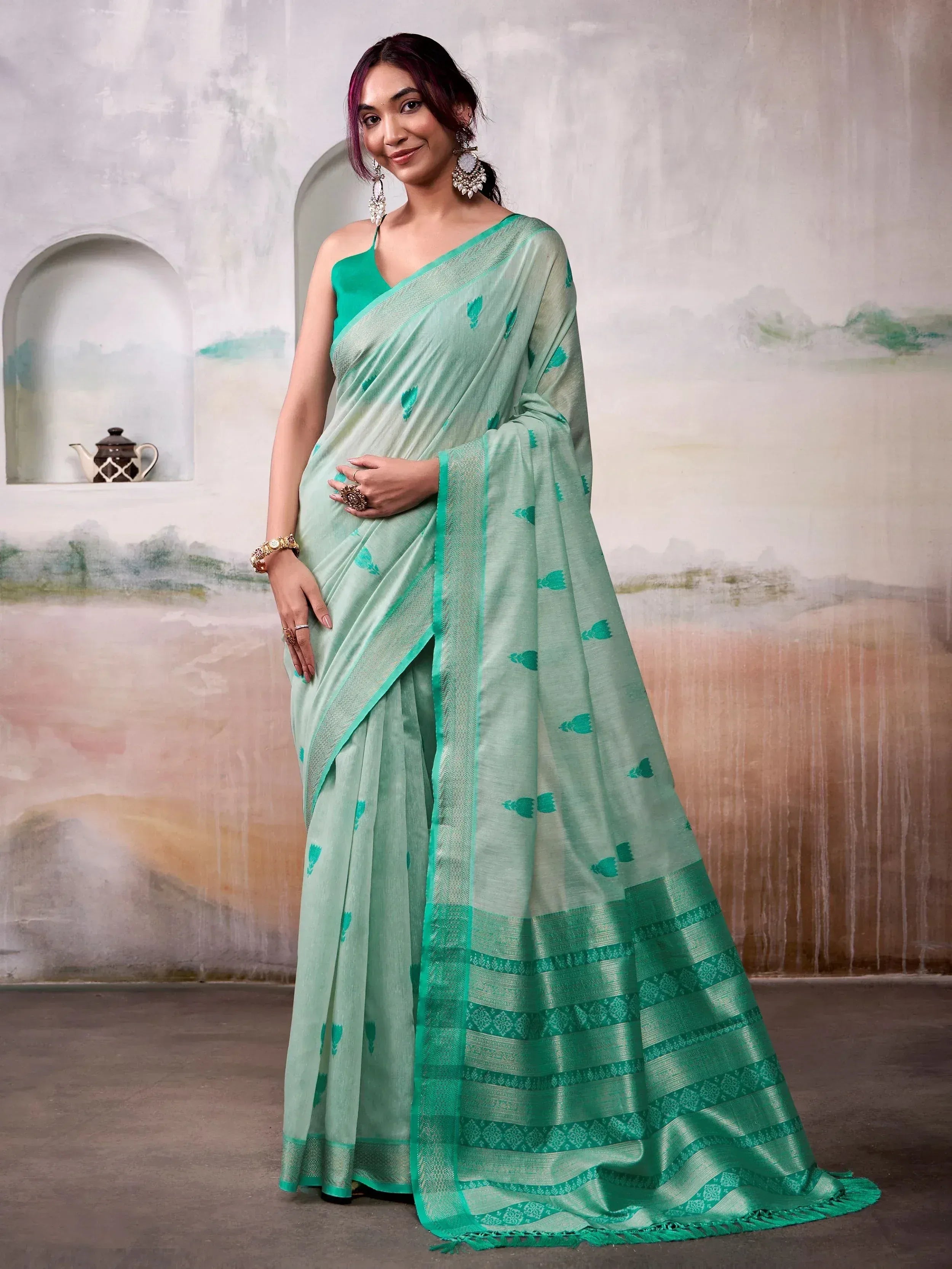 Mint green saree with teal leaf print and woven border, paired with matching blouse for ethnic wear