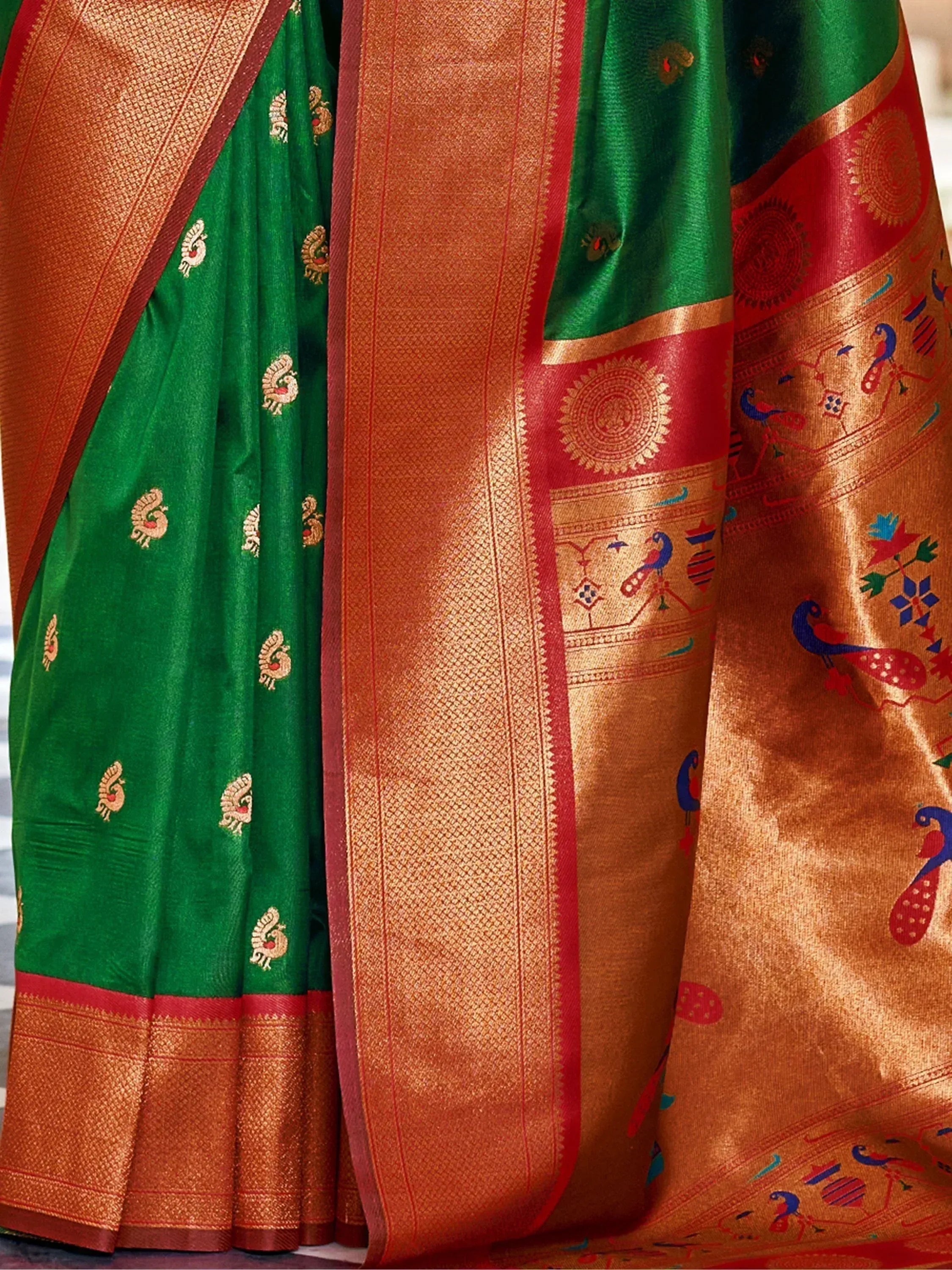 Green and gold Indian saree with peacock motifs and intricate border design, perfect for ethnic wear.