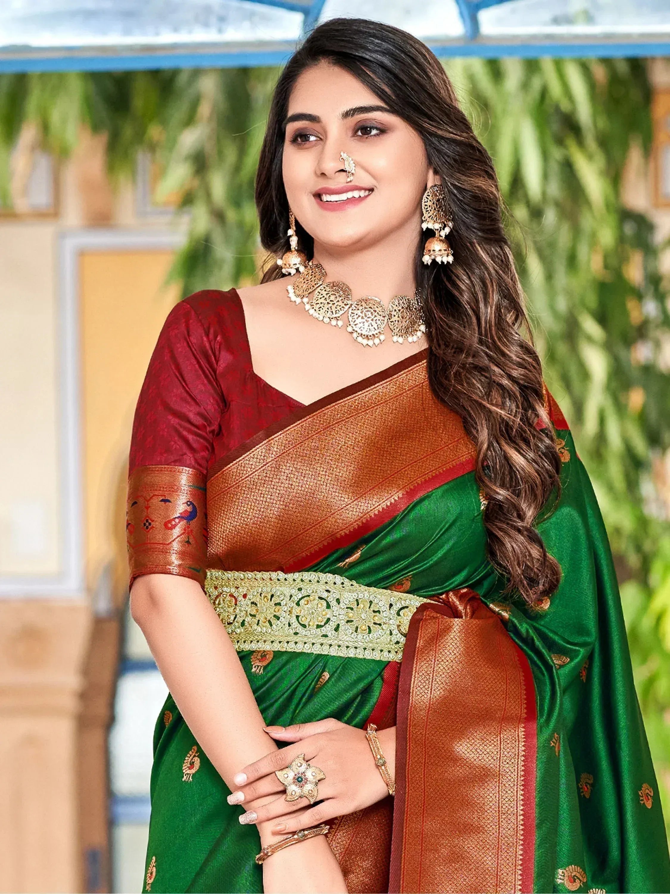 Woman in green and maroon designer saree with gold embroidery, traditional Indian ethnic wear