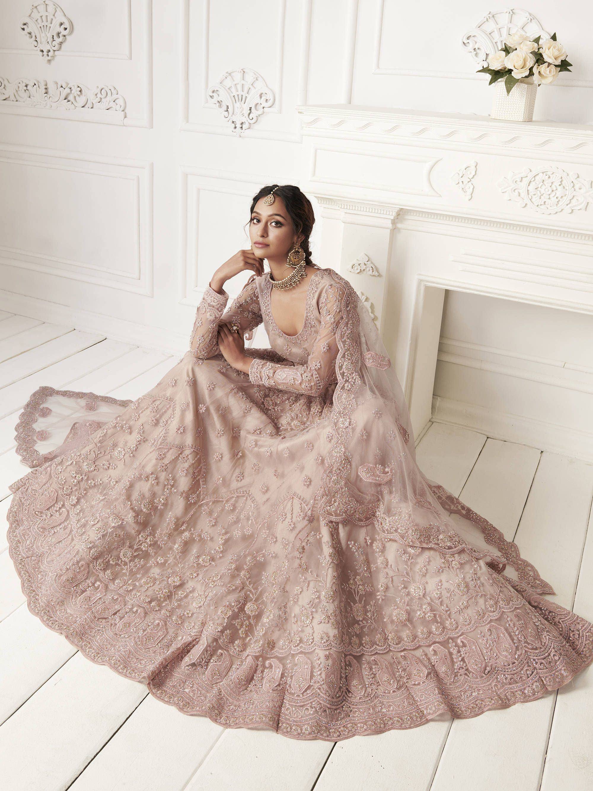Elegant blush pink embroidered lehenga choli with sheer dupatta, perfect for Indian weddings and festive occasions.