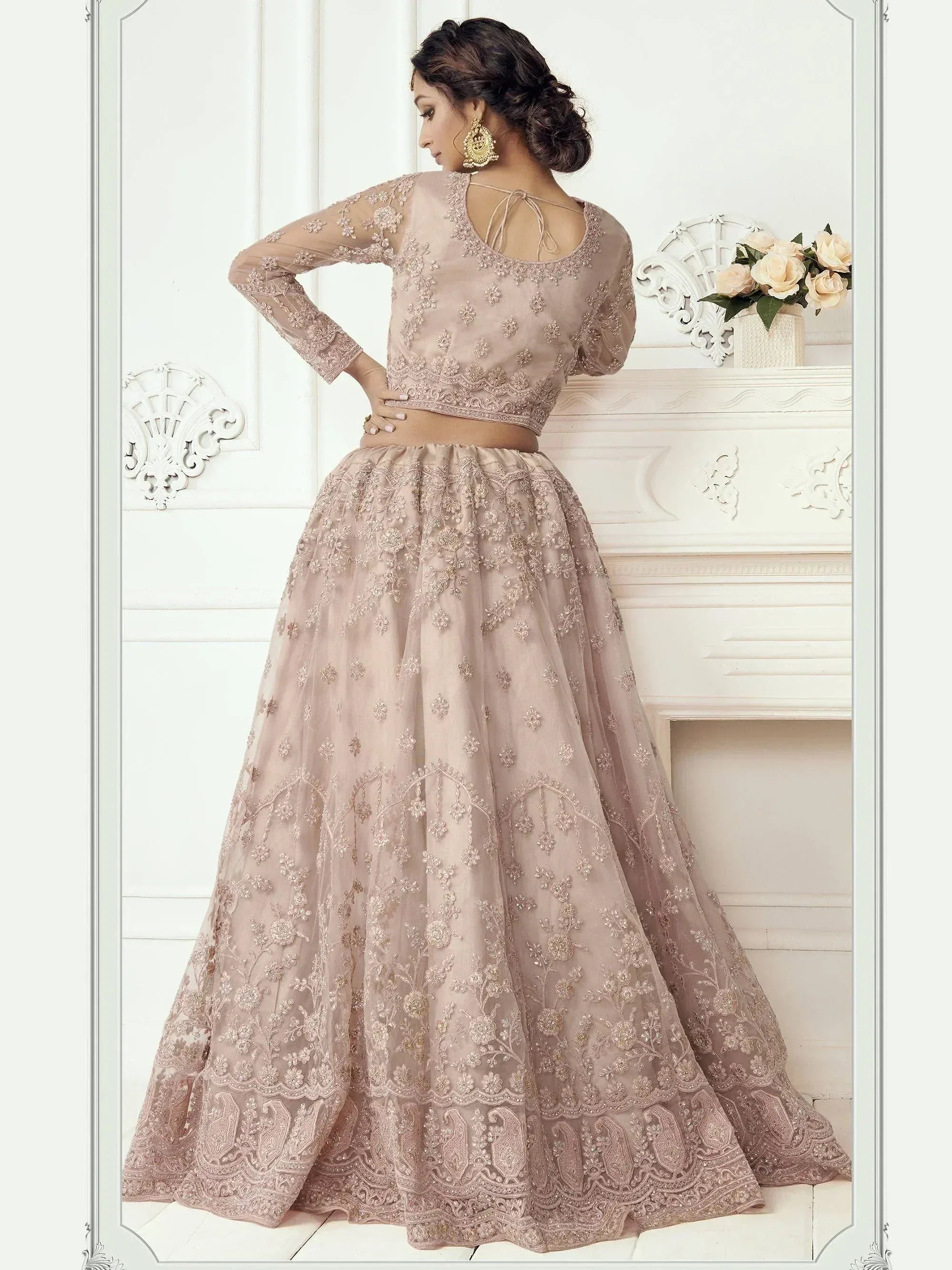 Elegant blush pink embroidered lehenga choli with sheer long sleeves and floral detailing, perfect for Indian weddings.