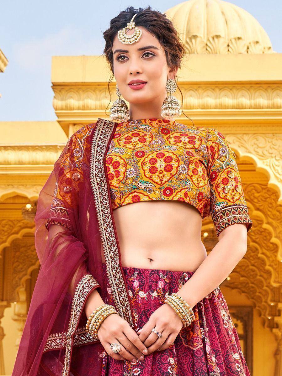 Indian designer lehenga choli with floral print, maroon dupatta, and gold jewelry, perfect for weddings