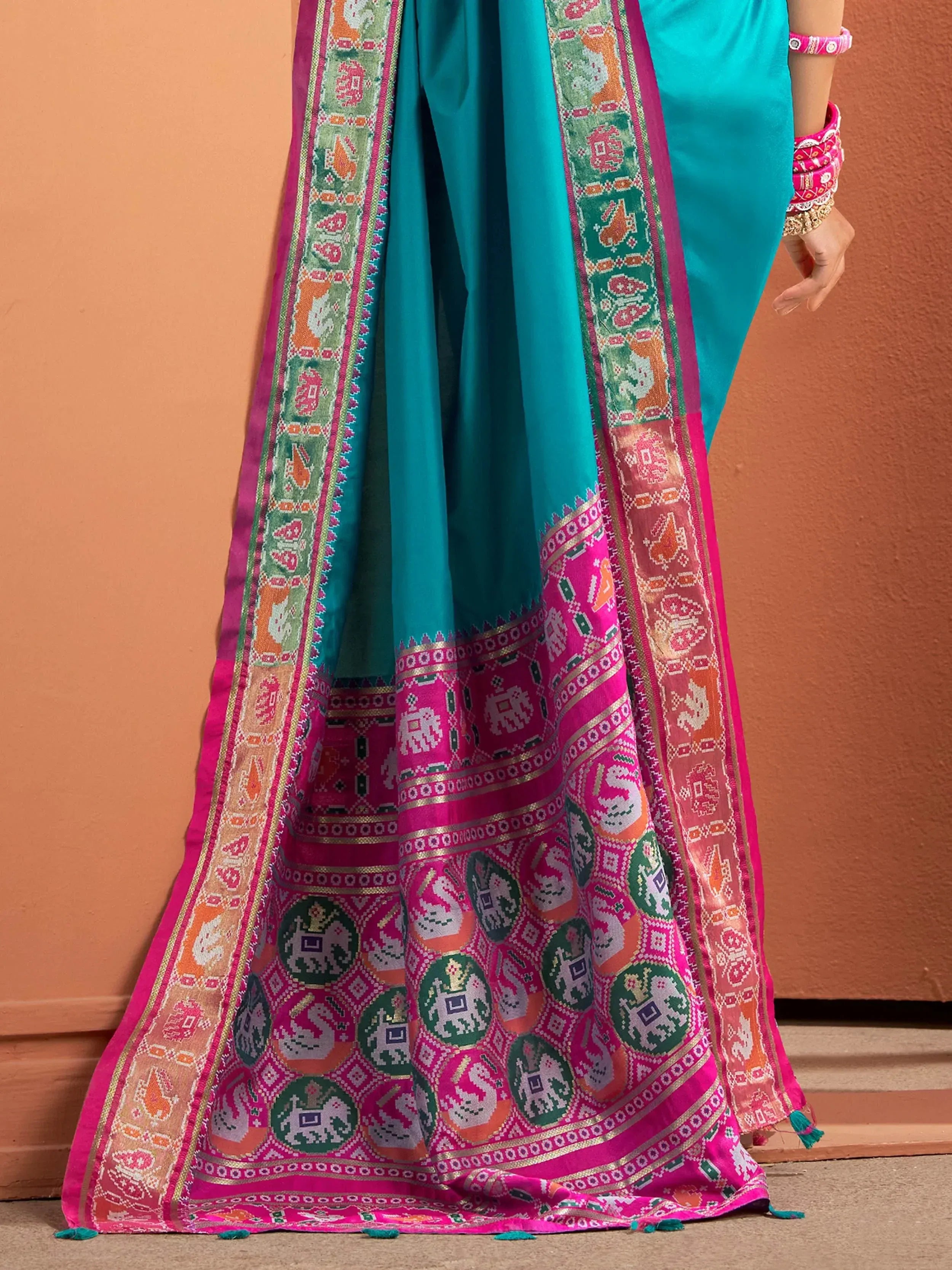 Teal and pink ethnic saree with elephant and peacock motifs, traditional Indian wear