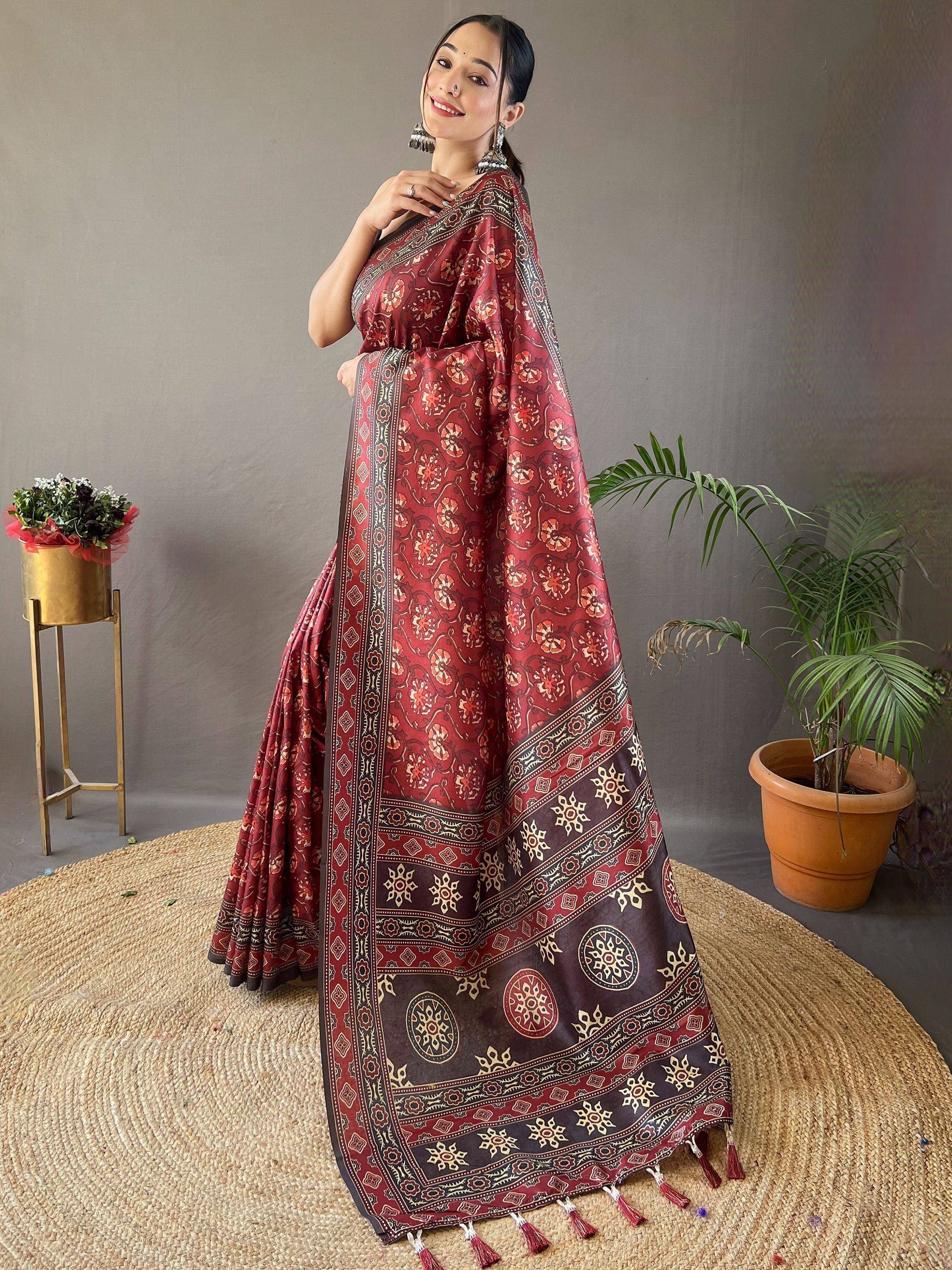 Woman in maroon floral print saree with gold border and tassels, Indian ethnic wear