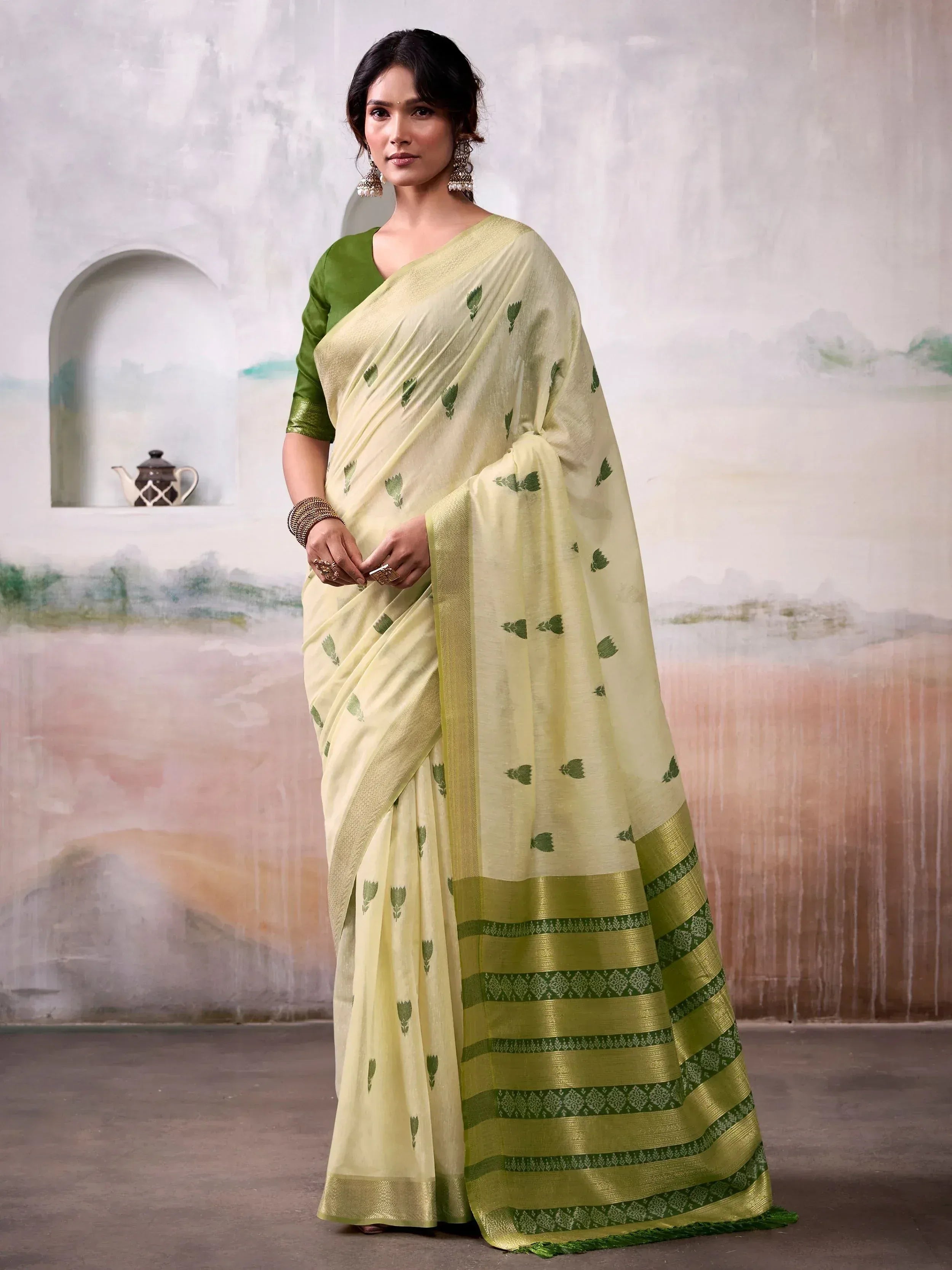 Light green saree with leaf print and woven border, paired with matching blouse for ethnic wear