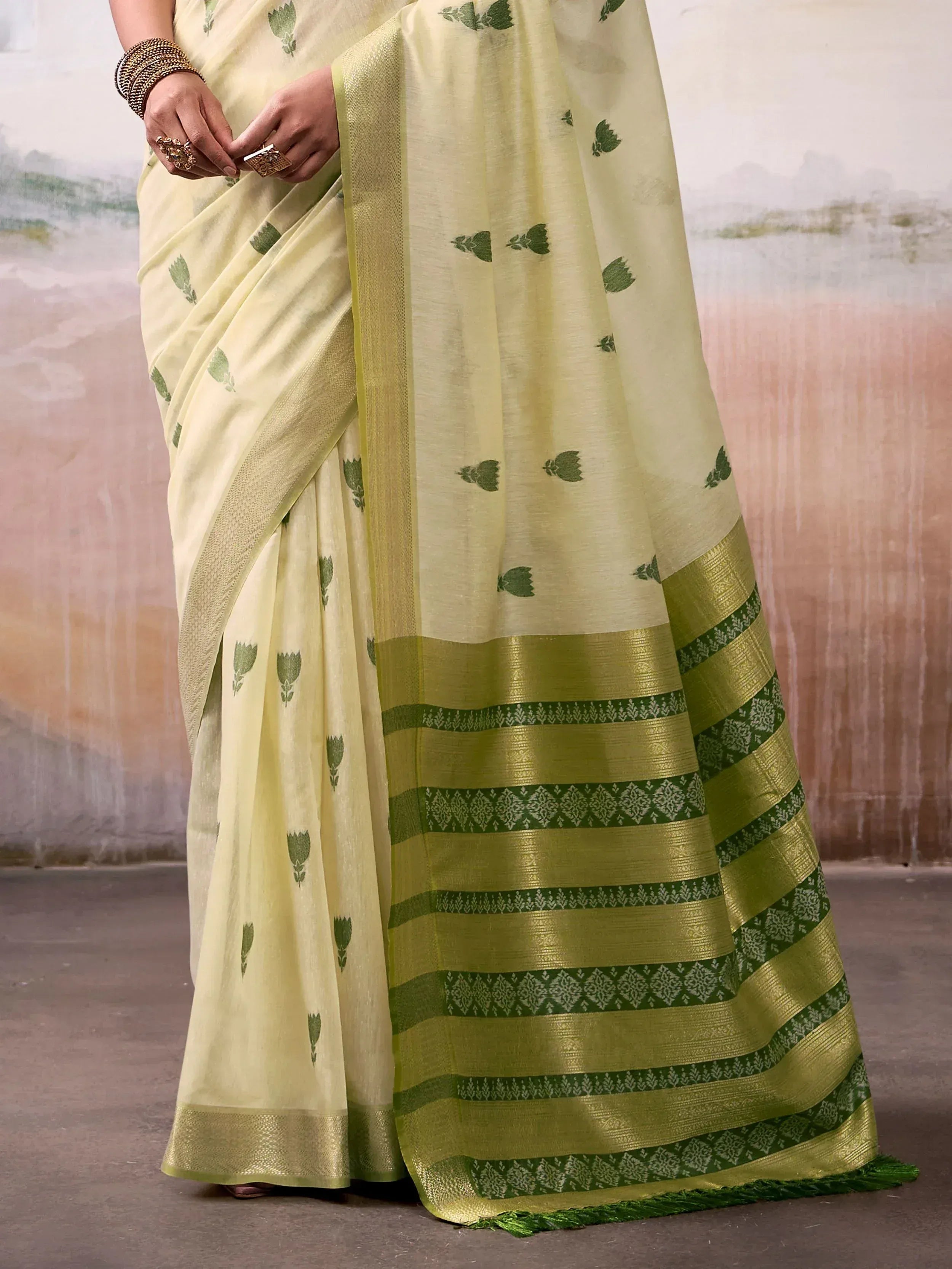 Light yellow saree with green floral prints and intricate border designs, perfect for ethnic occasions.
