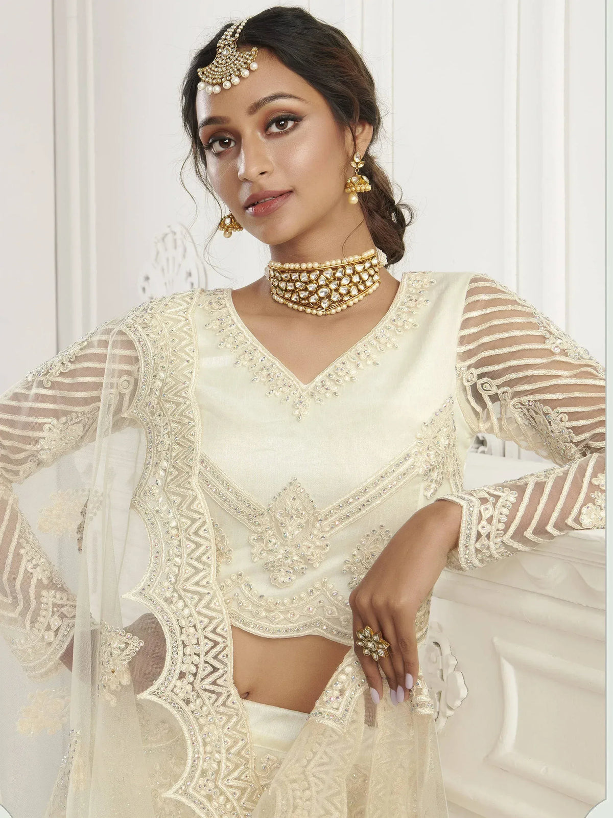 Elegant cream ethnic wear with intricate embroidery and pearl jewelry