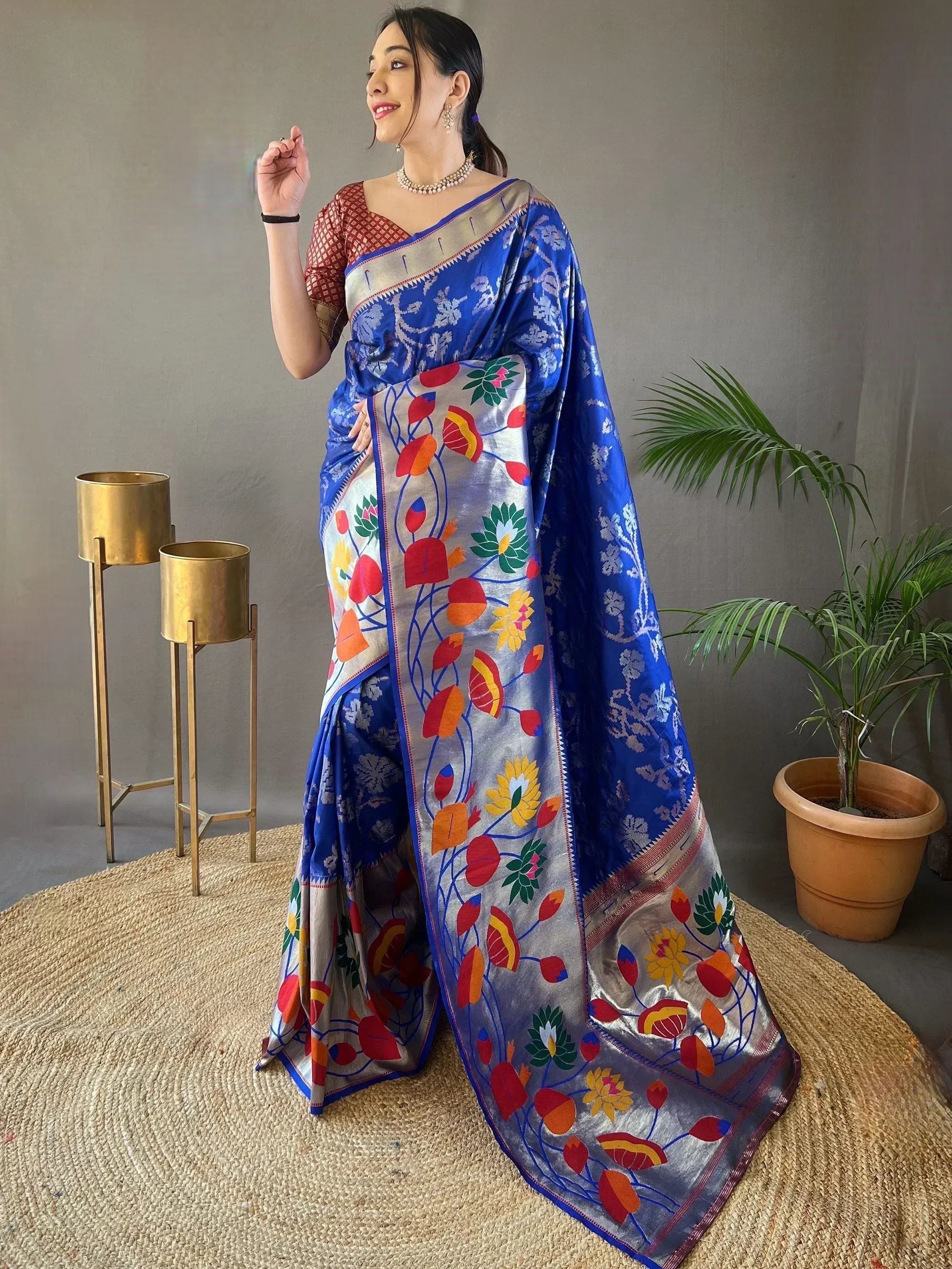 Blue floral saree with vibrant embroidery, paired with red blouse, perfect for ethnic occasions.