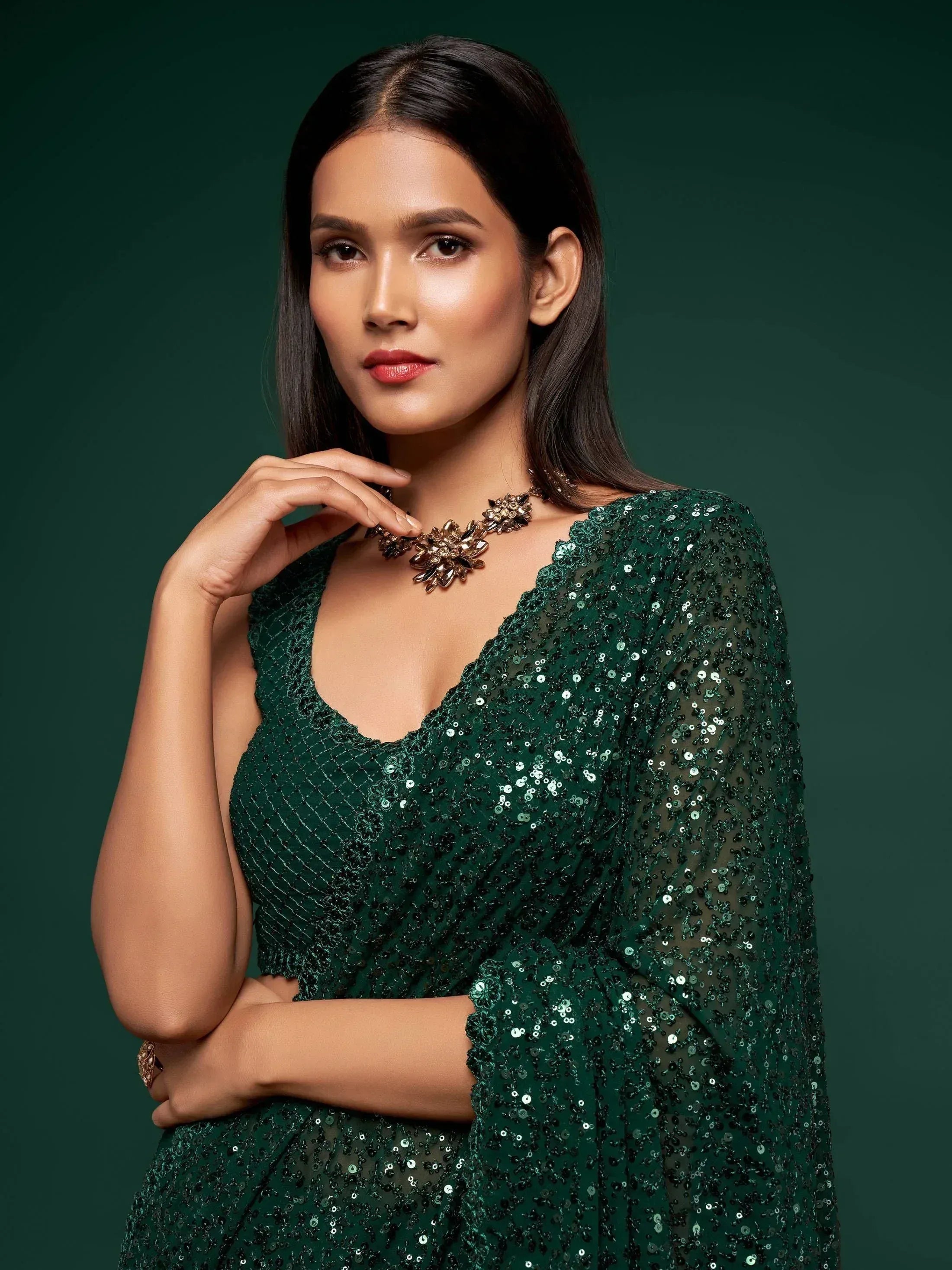 Emerald green sequin ethnic gown with sheer sleeves and floral necklace for festive occasions