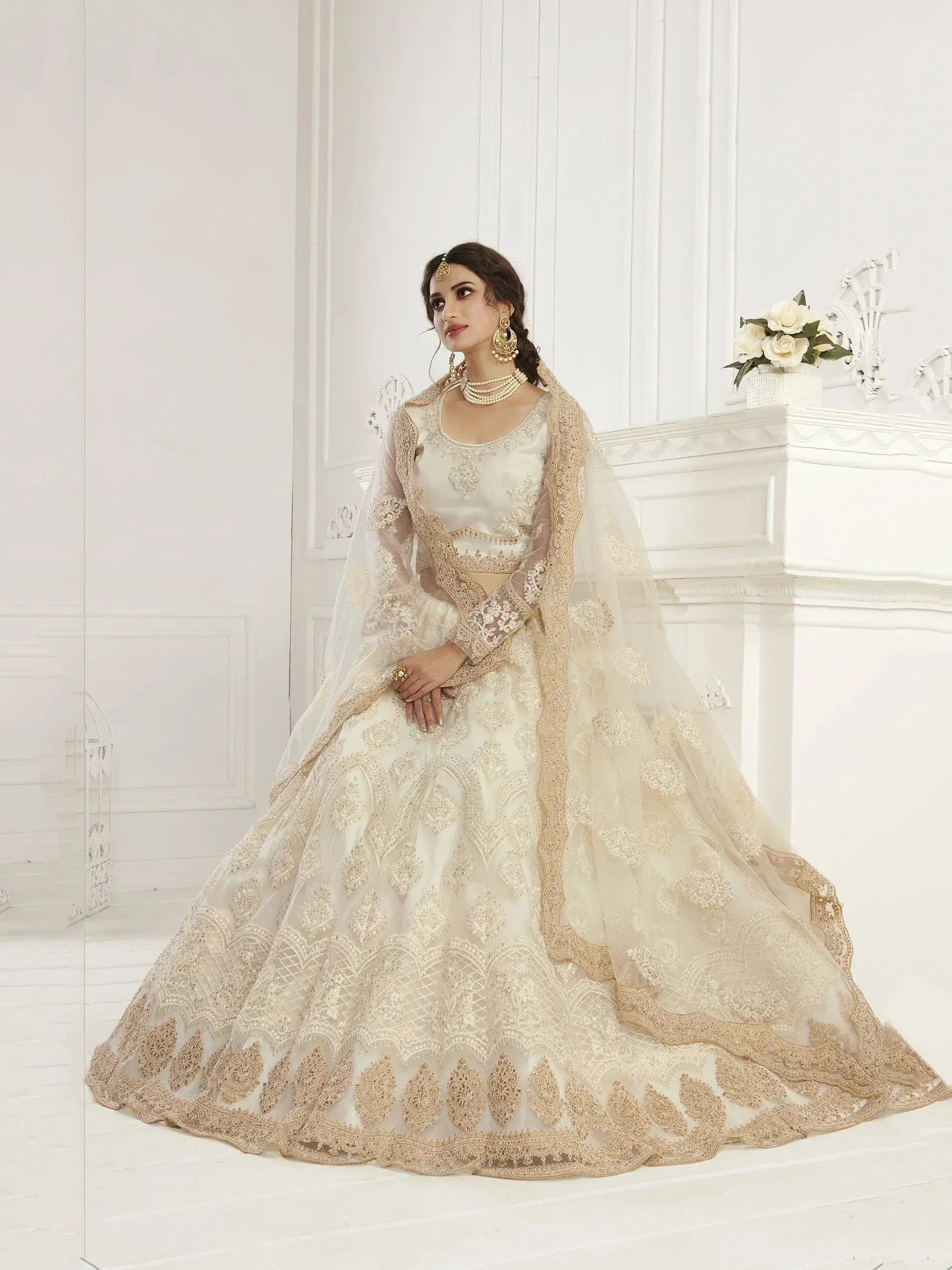 Elegant ivory lehenga choli with gold embroidery, perfect for weddings and festive occasions.
