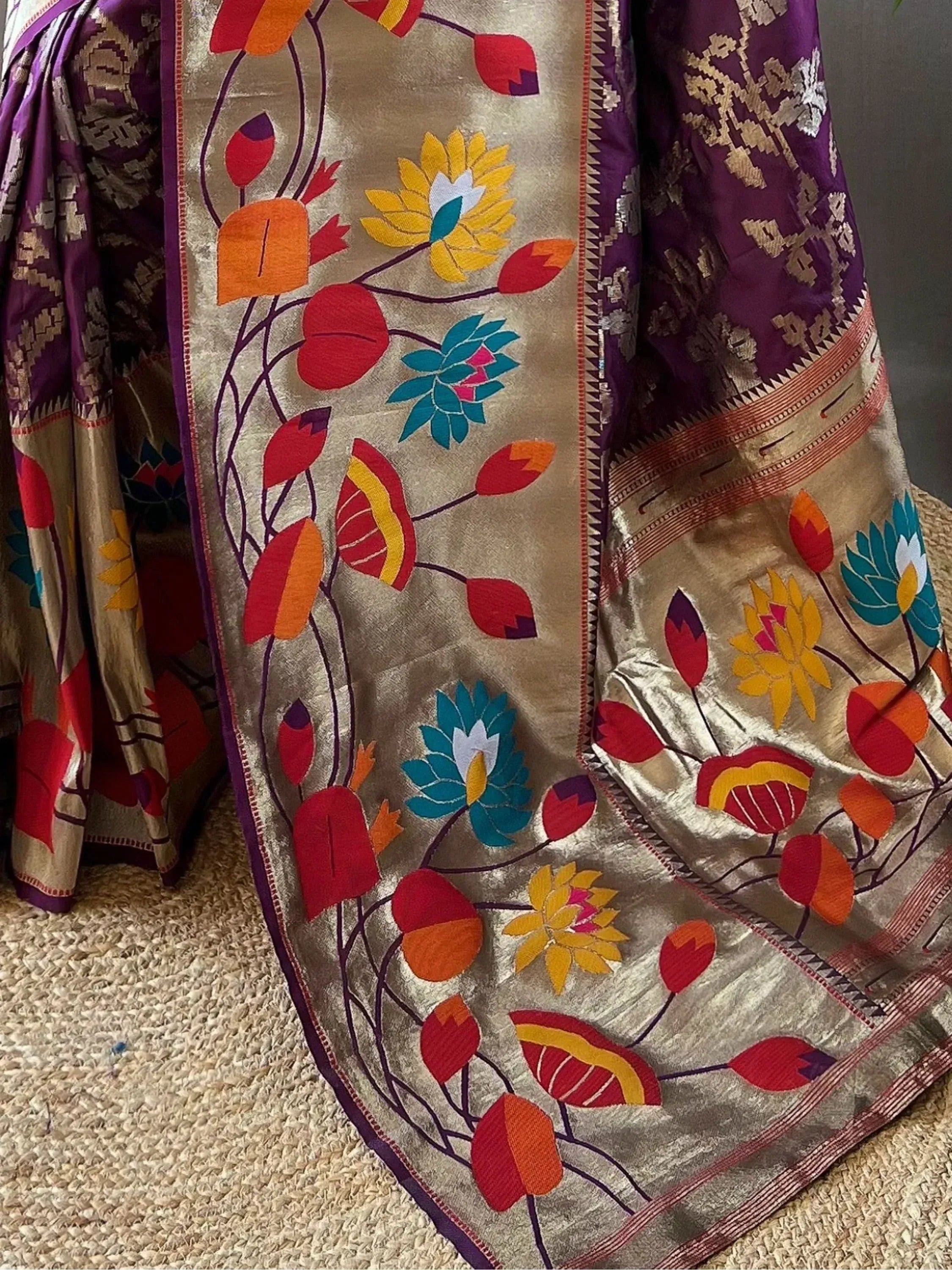 Vibrant floral embroidered saree with purple and gold accents, perfect for ethnic occasions.
