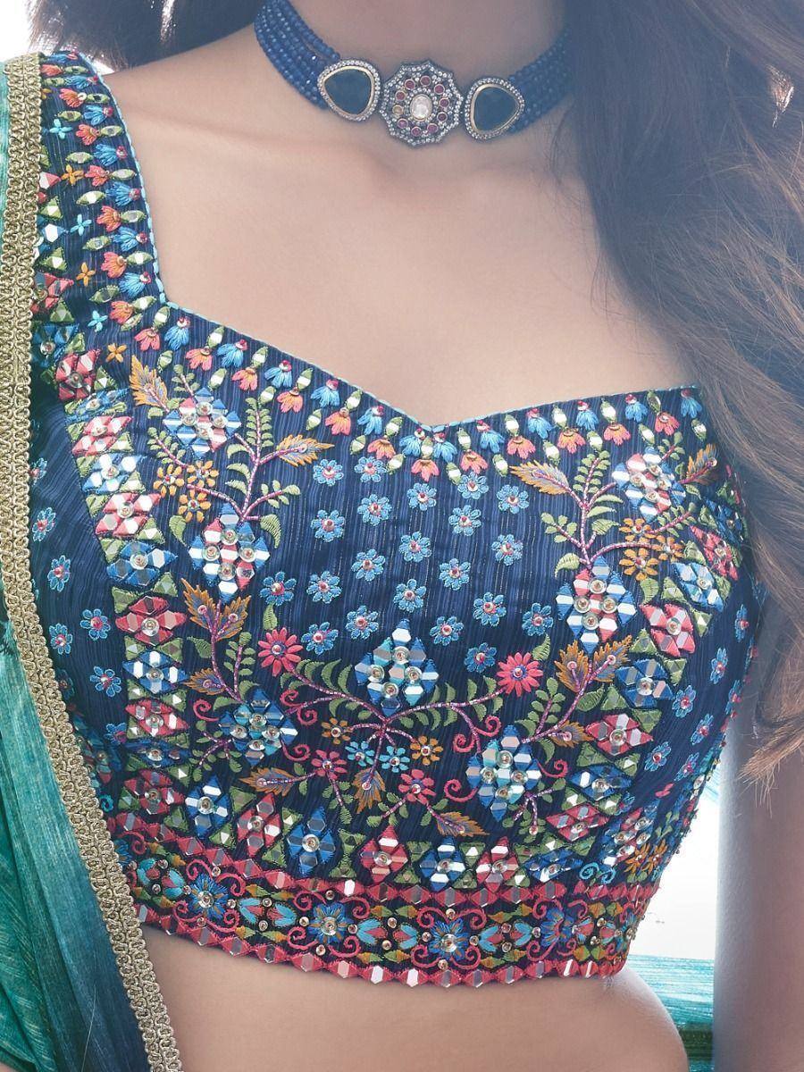 Blue floral embroidered blouse with mirror work, paired with green saree and statement choker for ethnic wear