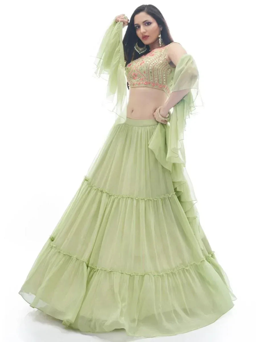 Light green tiered lehenga choli with floral embroidery and sheer dupatta, perfect for Indian ethnic occasions