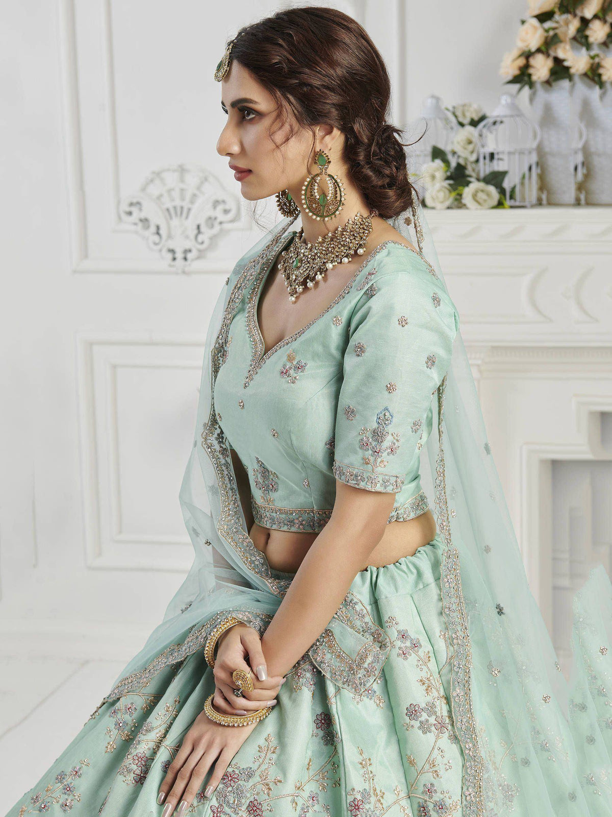 Mint green designer lehenga choli with floral embroidery and gold detailing, perfect for Indian weddings