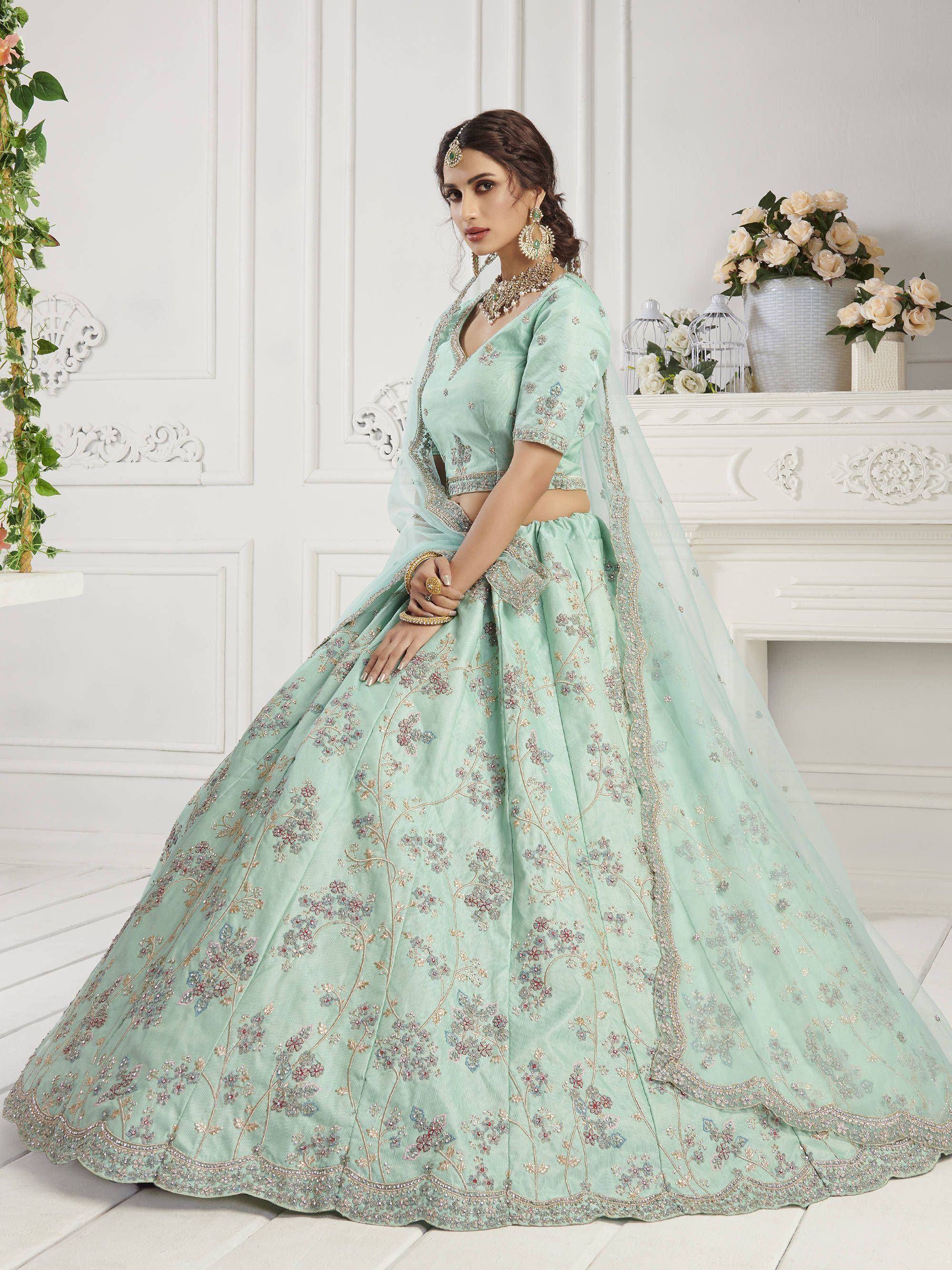 Mint green designer lehenga choli with floral embroidery and gold detailing, perfect for weddings and festive occasions.