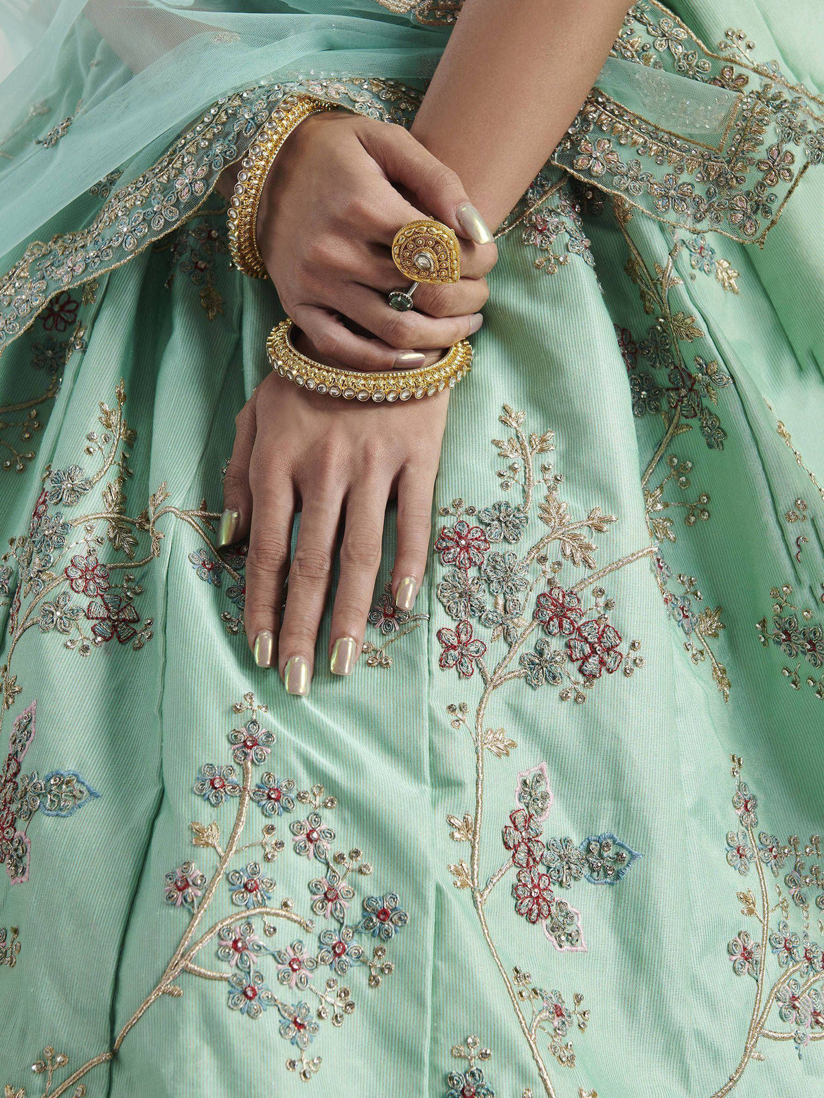 Mint green designer lehenga with floral embroidery and gold jewelry
