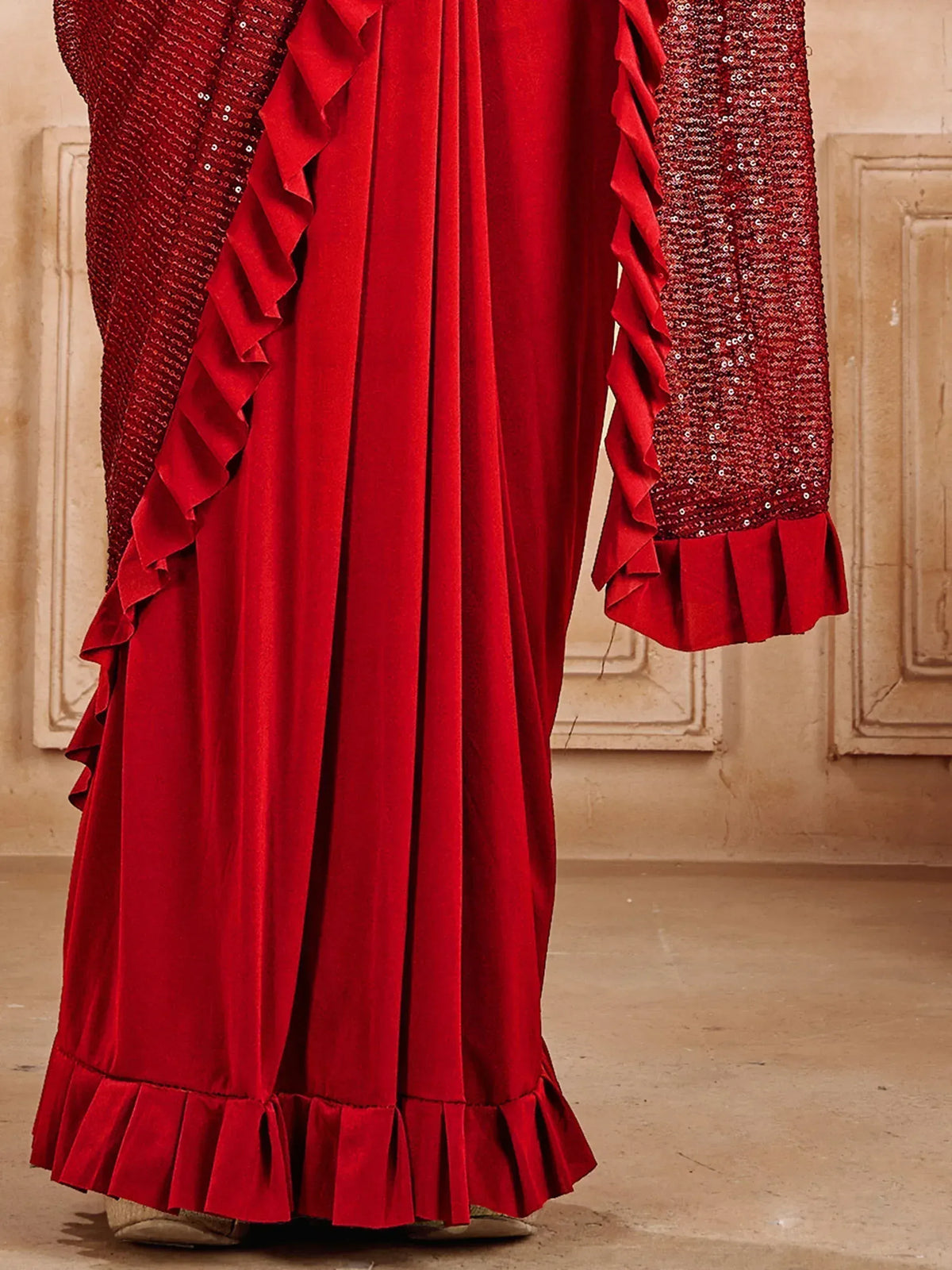 Red velvet ethnic gown with sequin sleeves and ruffle details, perfect for festive occasions.