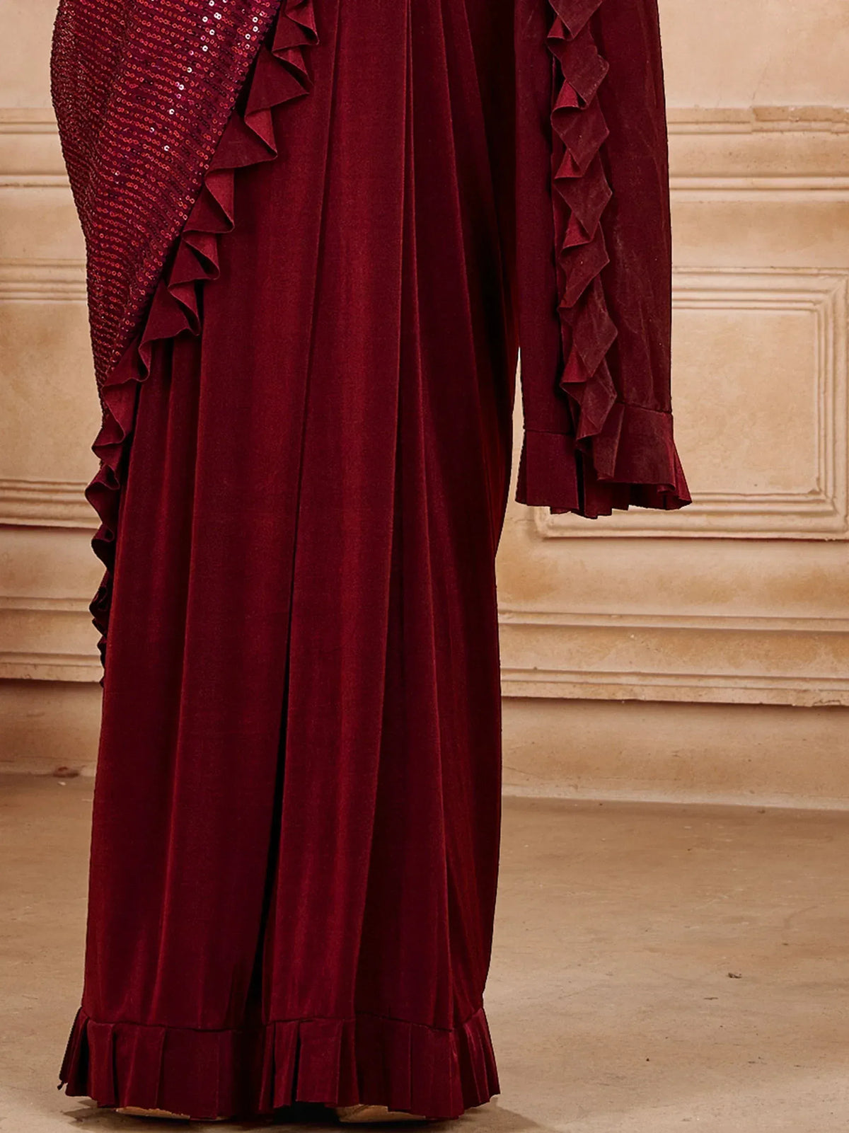 Burgundy velvet ethnic gown with ruffles and sequin detailing, perfect for festive occasions.