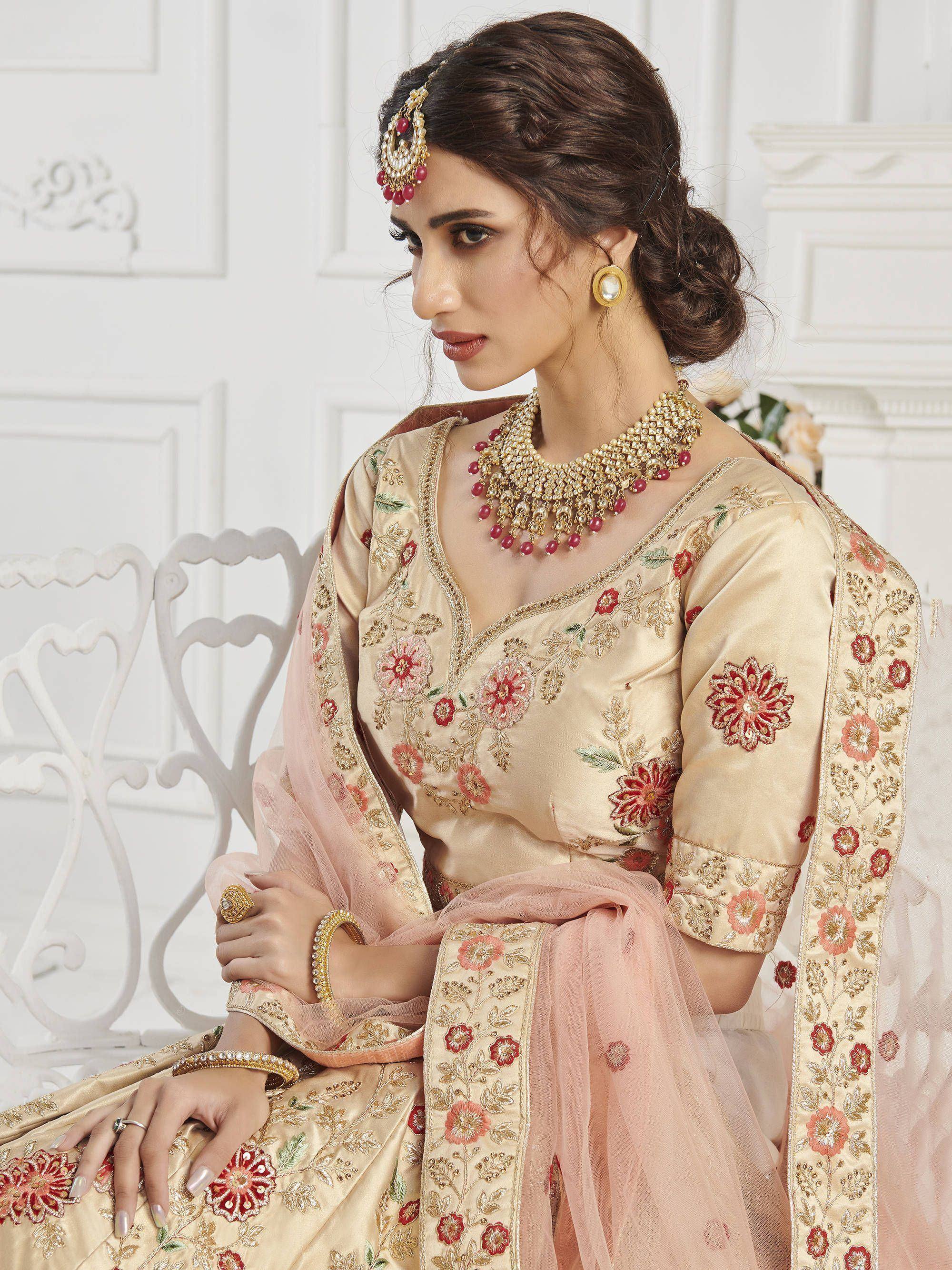 Elegant beige embroidered lehenga choli with floral motifs, perfect for Indian weddings and festive occasions.