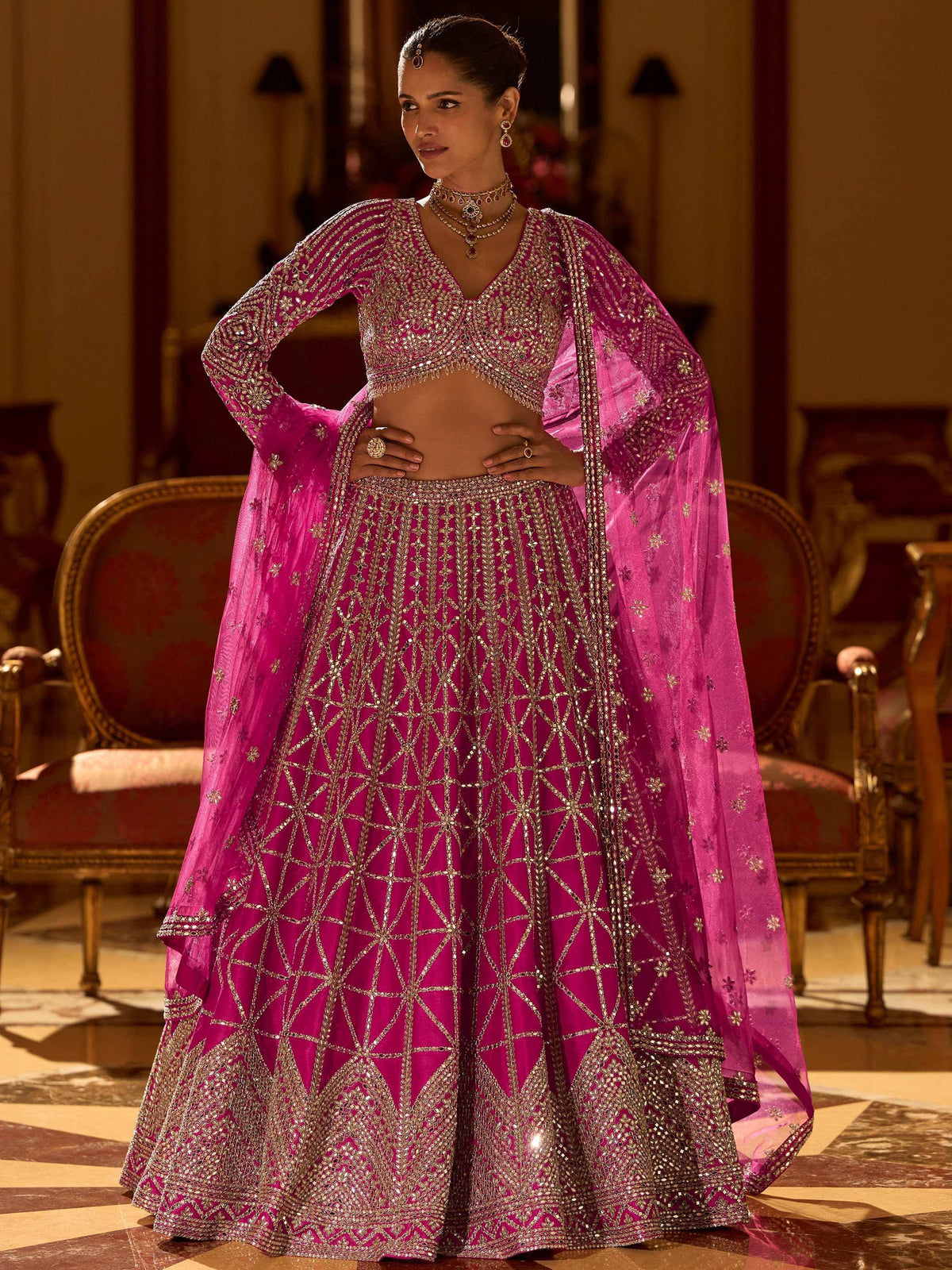 Fuchsia pink designer lehenga choli with gold embroidery, perfect for Indian weddings and festive occasions.