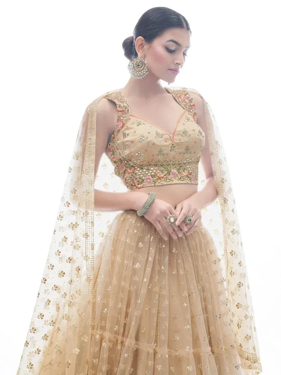 Elegant beige embroidered lehenga choli with floral motifs and sheer dupatta, perfect for Indian weddings or festive occasions.
