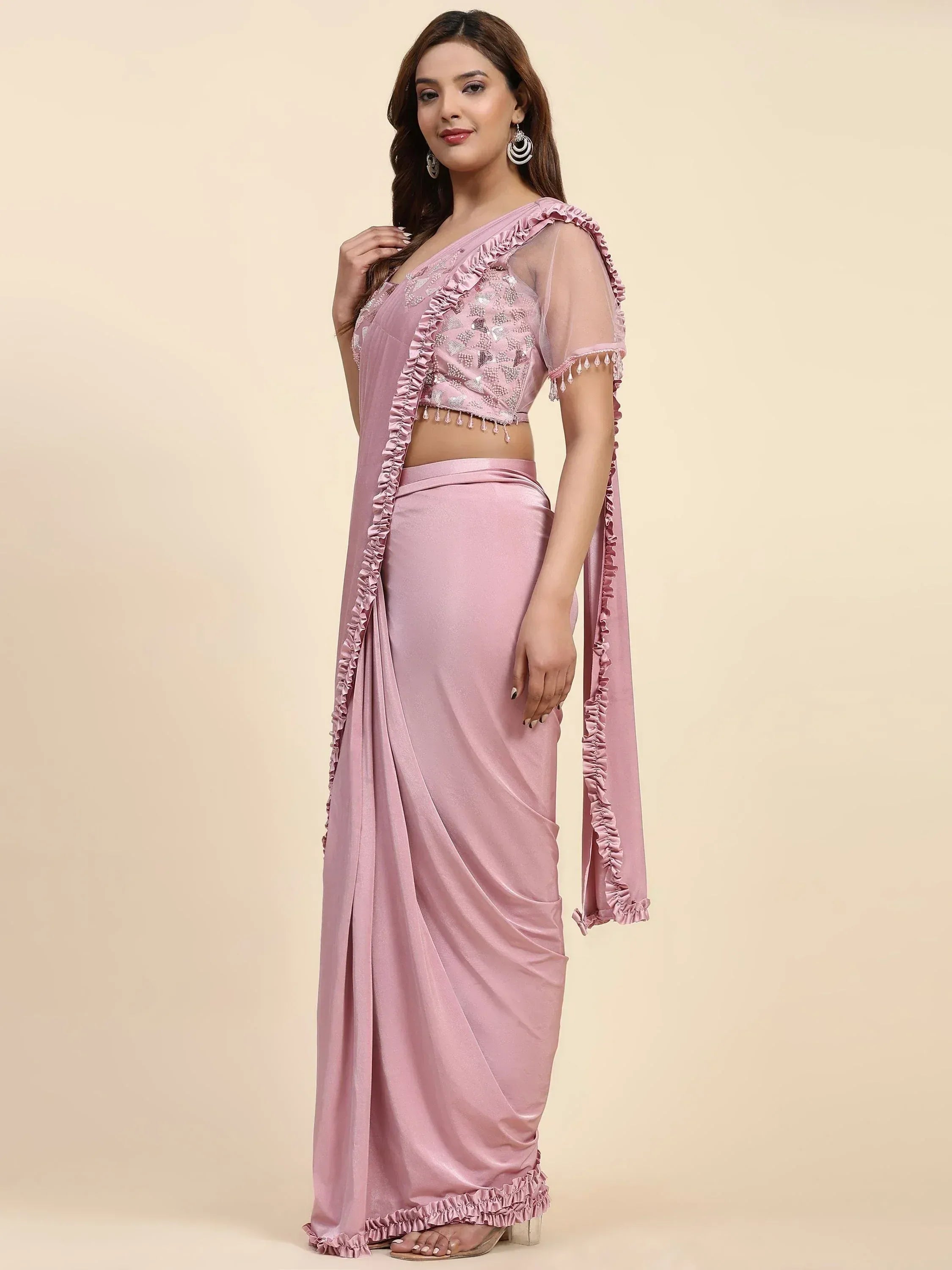 Pink designer saree with ruffled blouse and embellished detailing for ethnic wear