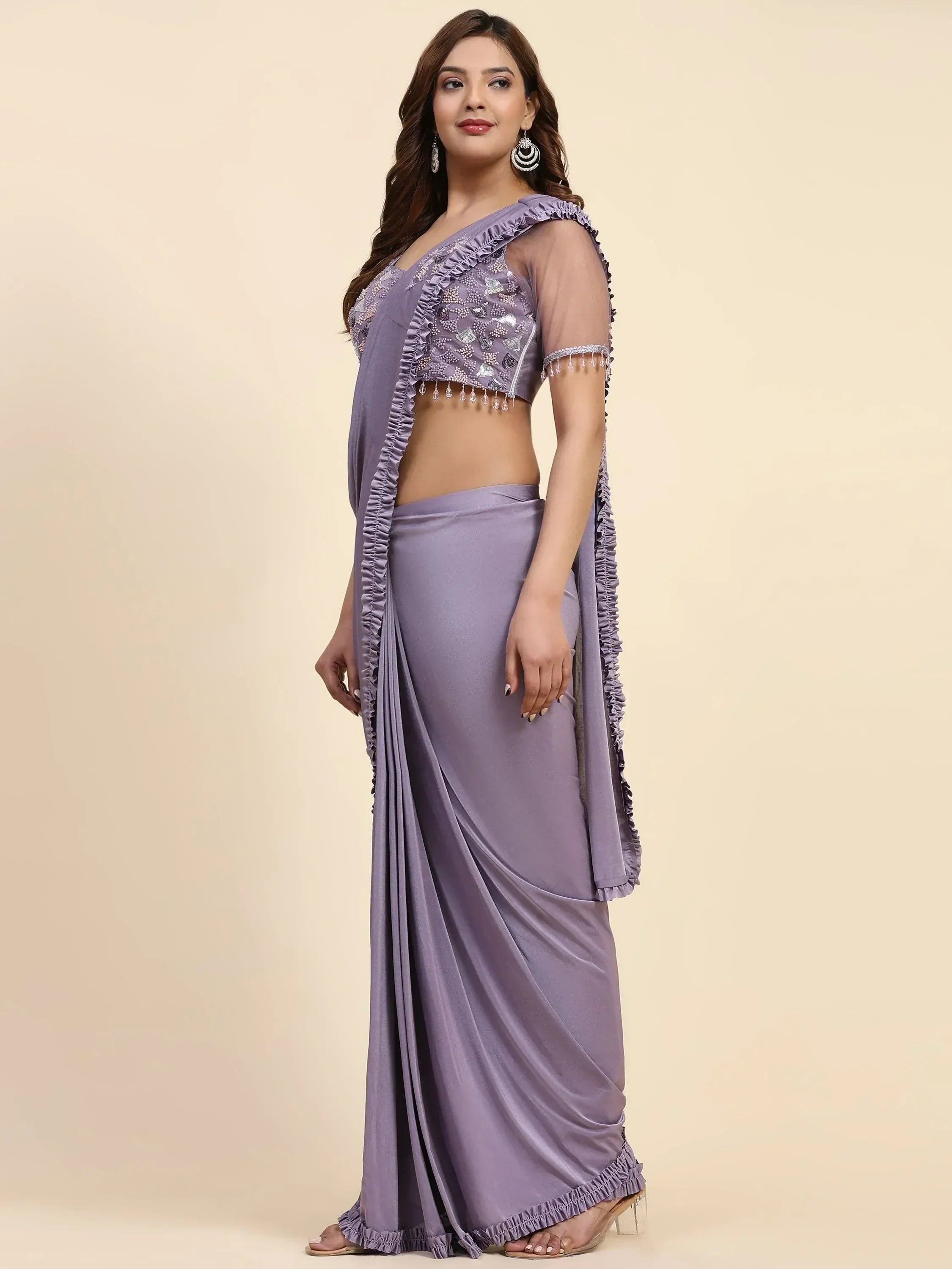 Lavender ethnic saree with ruffled blouse and sequin embroidery, perfect for Indian occasions.