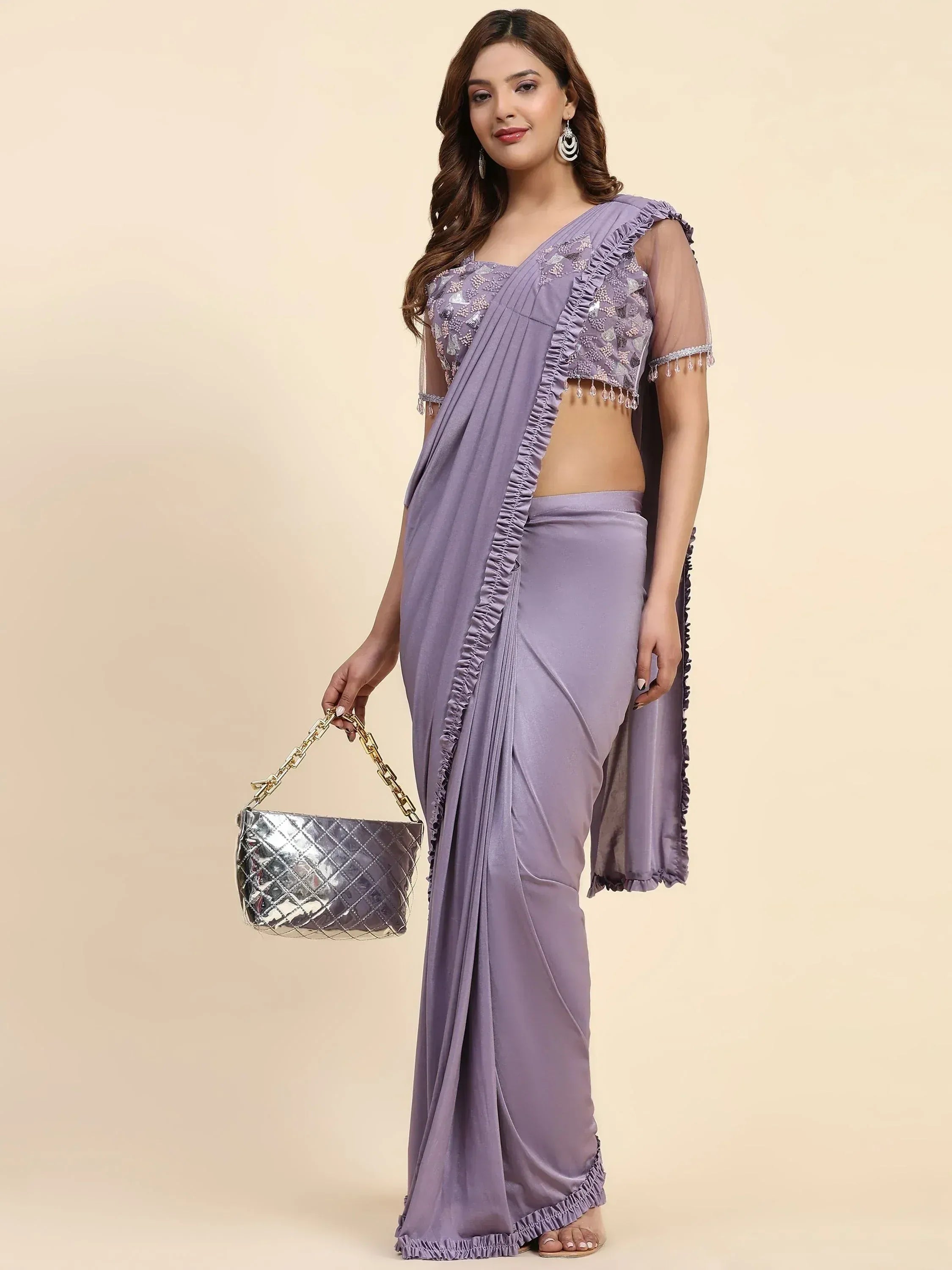 Lavender saree with ruffled blouse and sequin work, paired with silver handbag for ethnic wear