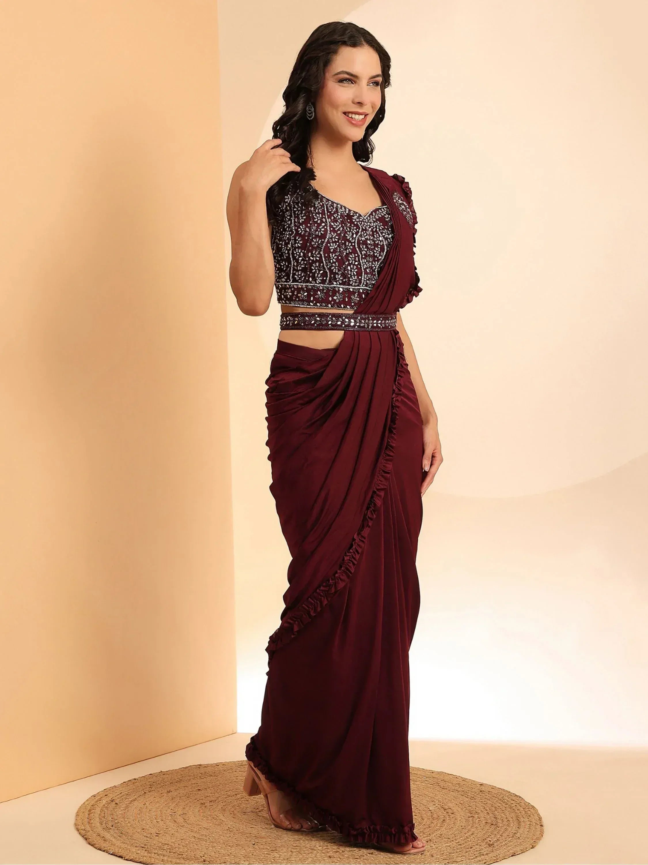 Maroon ethnic saree gown with embellished crop top and ruffled detailing, perfect for Indian occasions