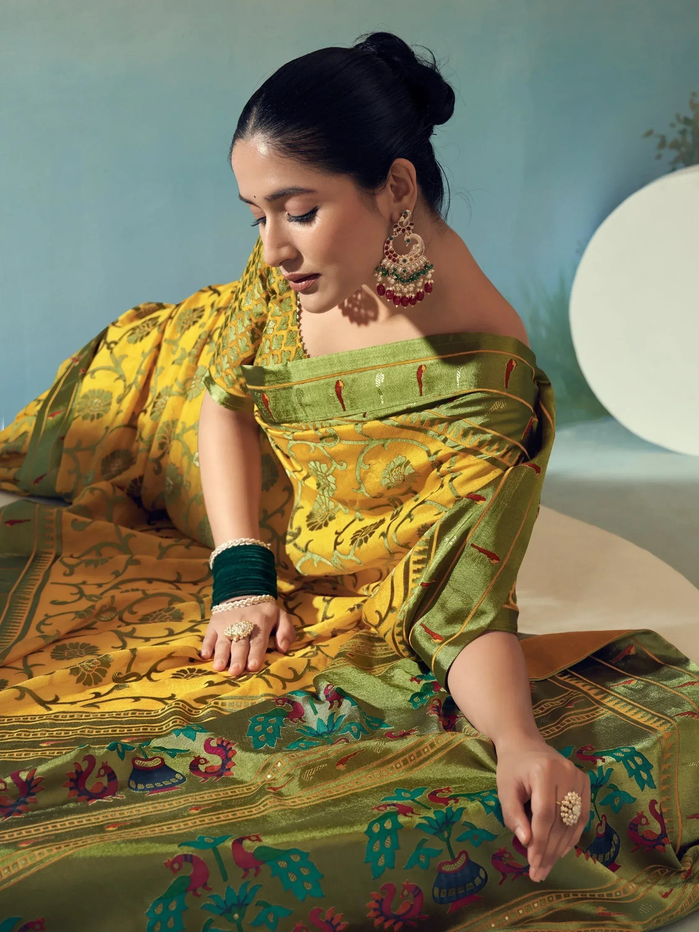 Woman in vibrant yellow and green designer saree with peacock print, traditional Indian ethnic wear