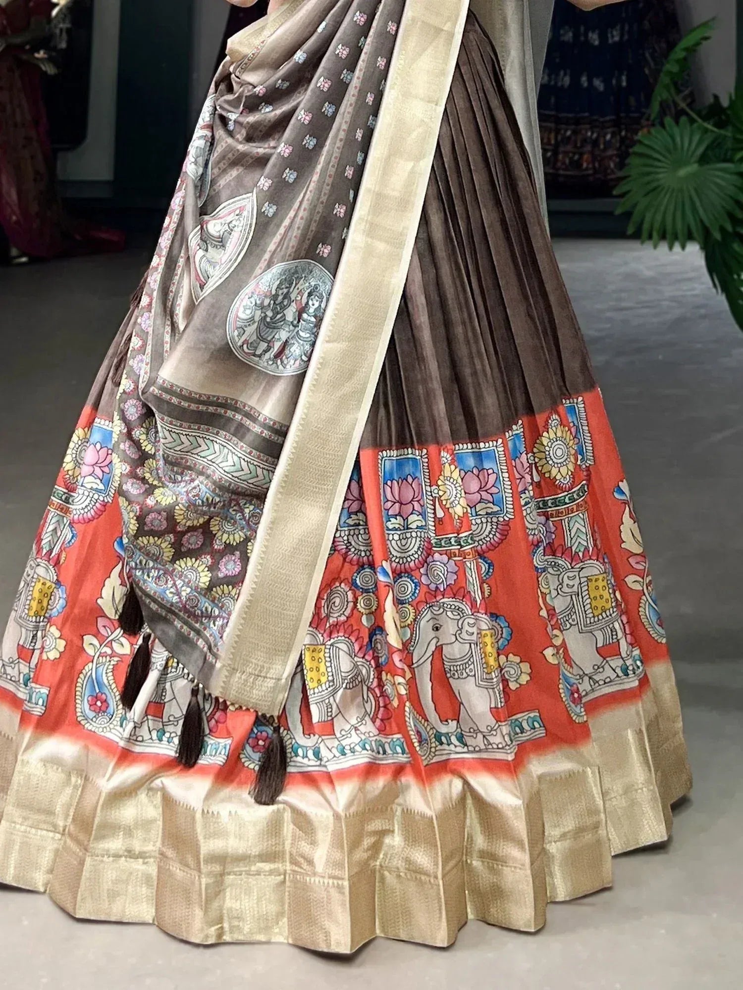 Brown and orange printed lehenga with elephant motifs and gold border, ethnic Indian wear