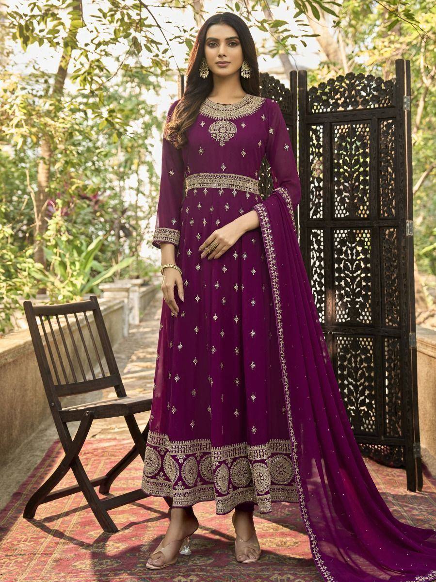 Woman in a purple embroidered Anarkali dress with dupatta, standing outdoors