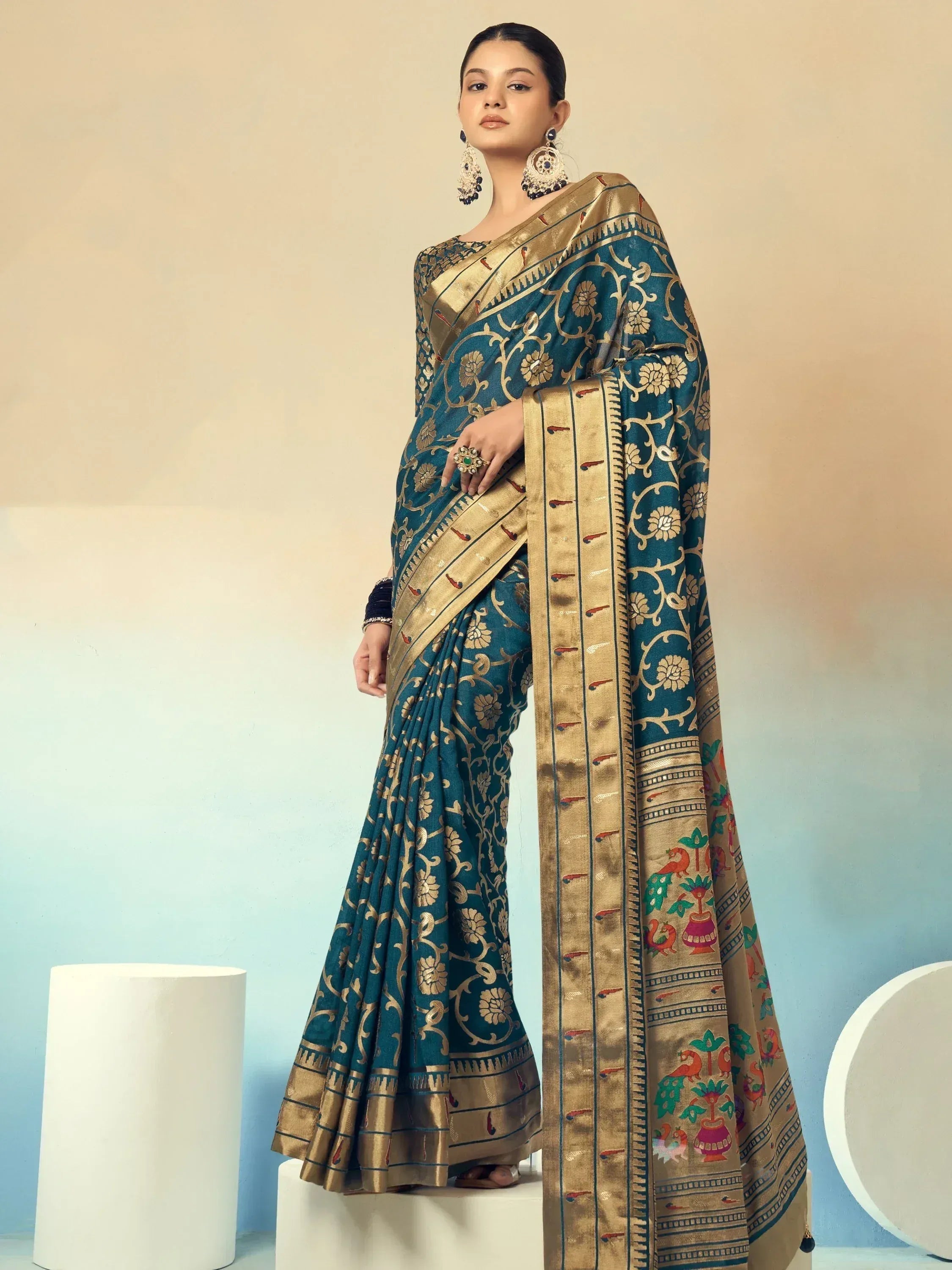 Teal and gold designer saree with floral and peacock motifs, perfect for Indian ethnic wear occasions.