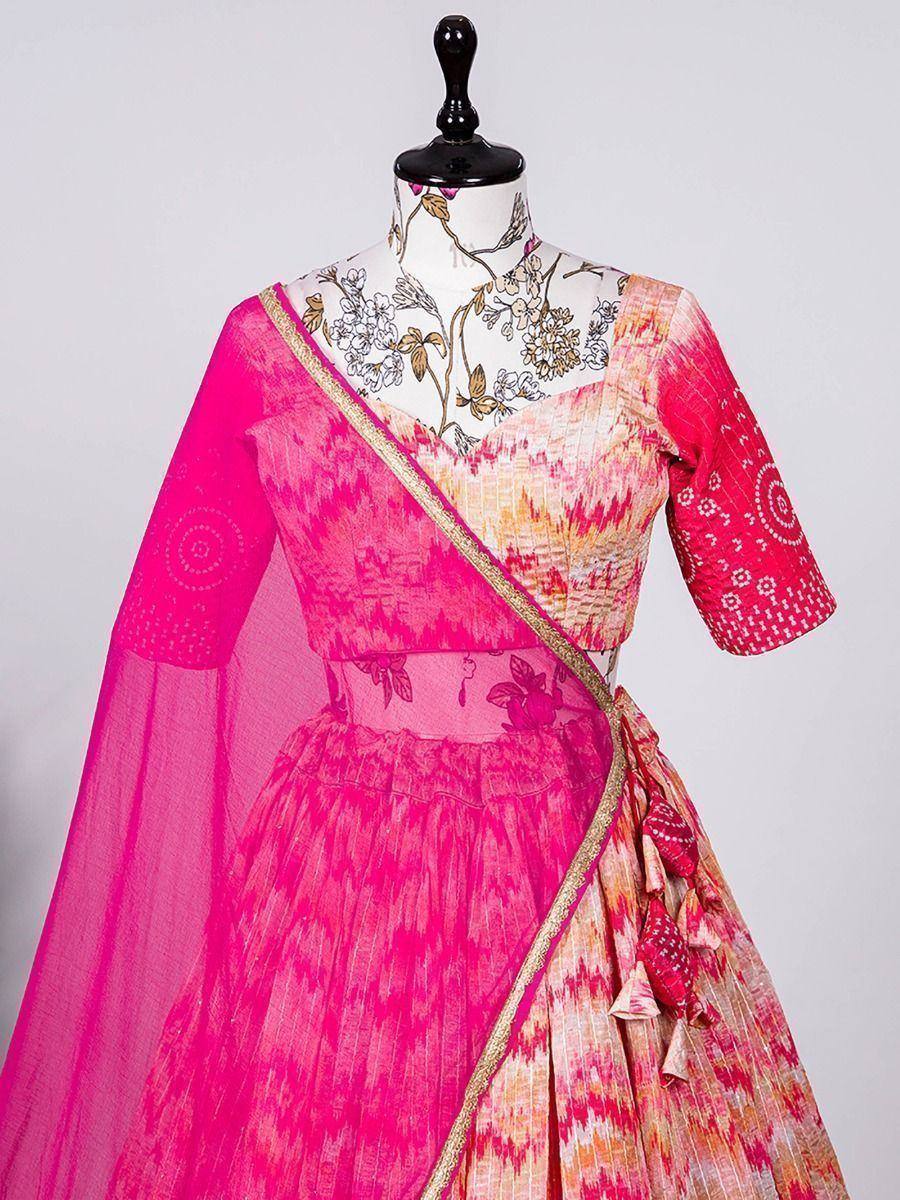 Vibrant pink and orange ikat print lehenga choli with floral blouse and sheer dupatta, perfect for Indian ethnic occasions.