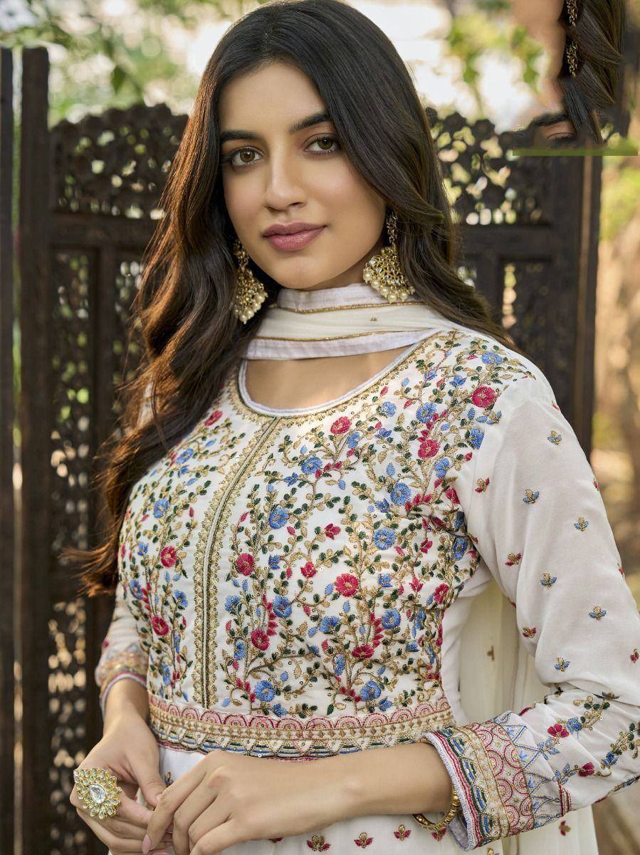 Woman in white floral embroidered ethnic kurti with gold jewelry, perfect for Indian occasions