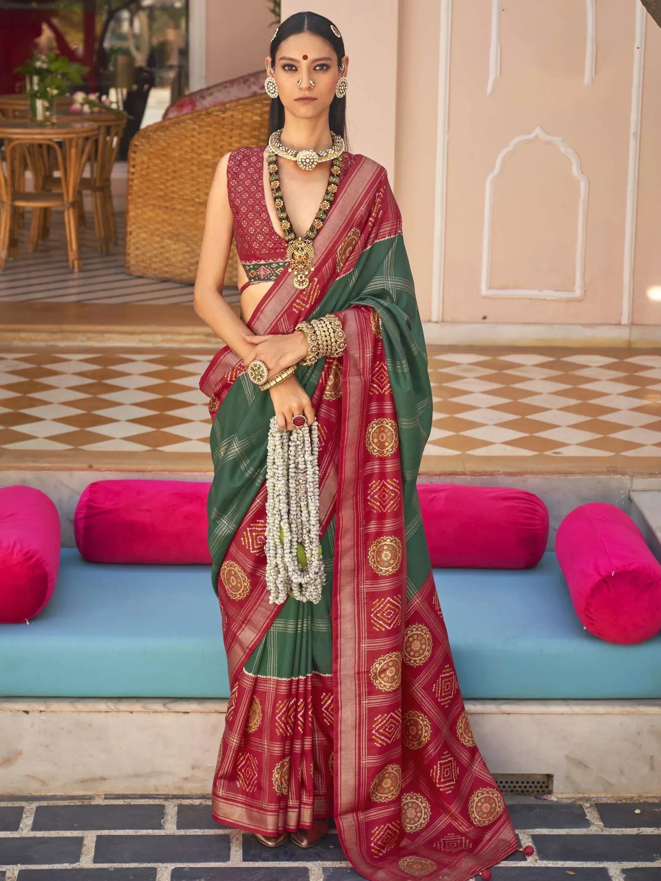 Woman in red and green designer saree with gold embroidery, traditional Indian ethnic wear