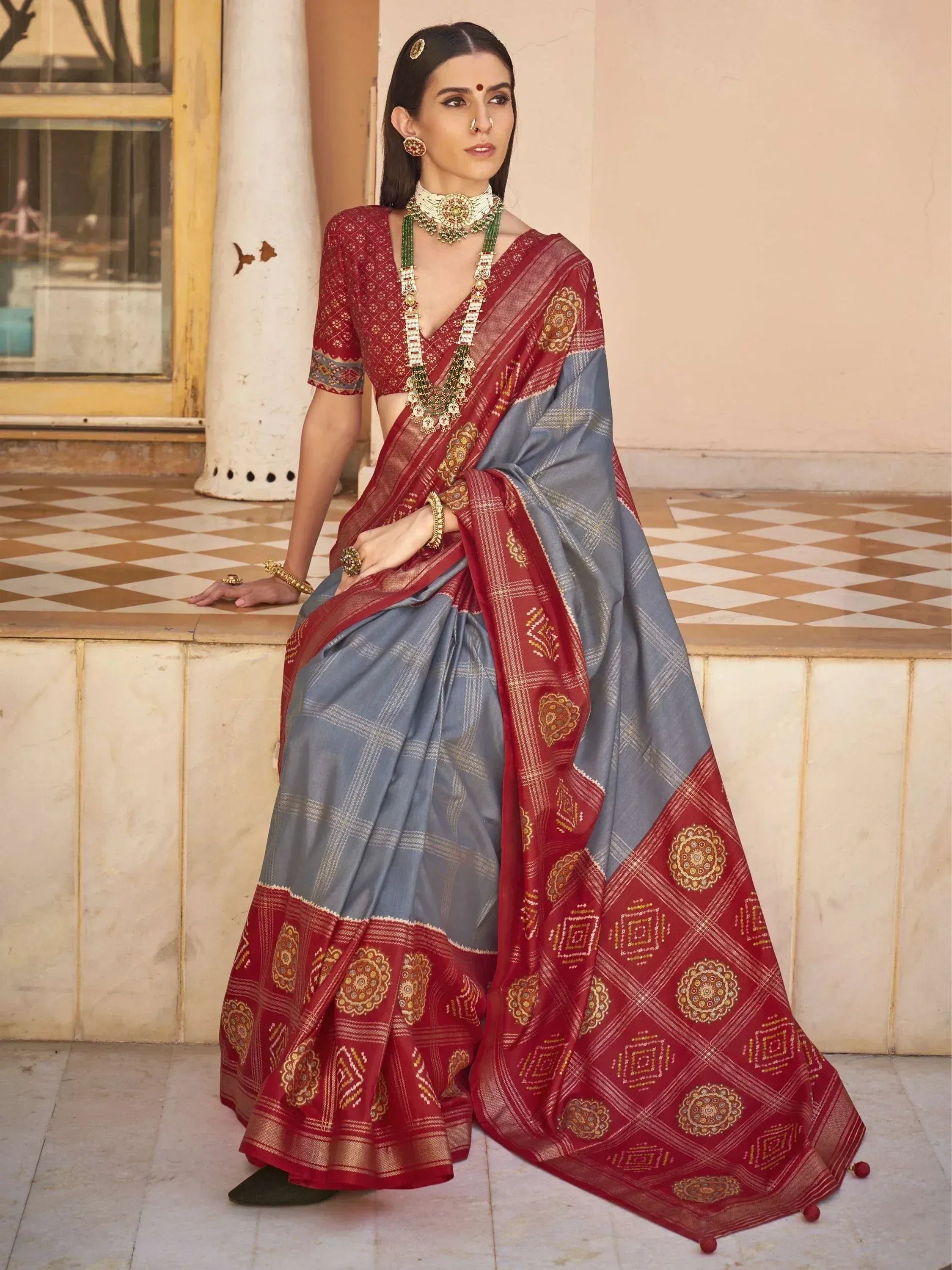 Grey and maroon designer saree with gold embroidery, paired with matching blouse and traditional jewelry