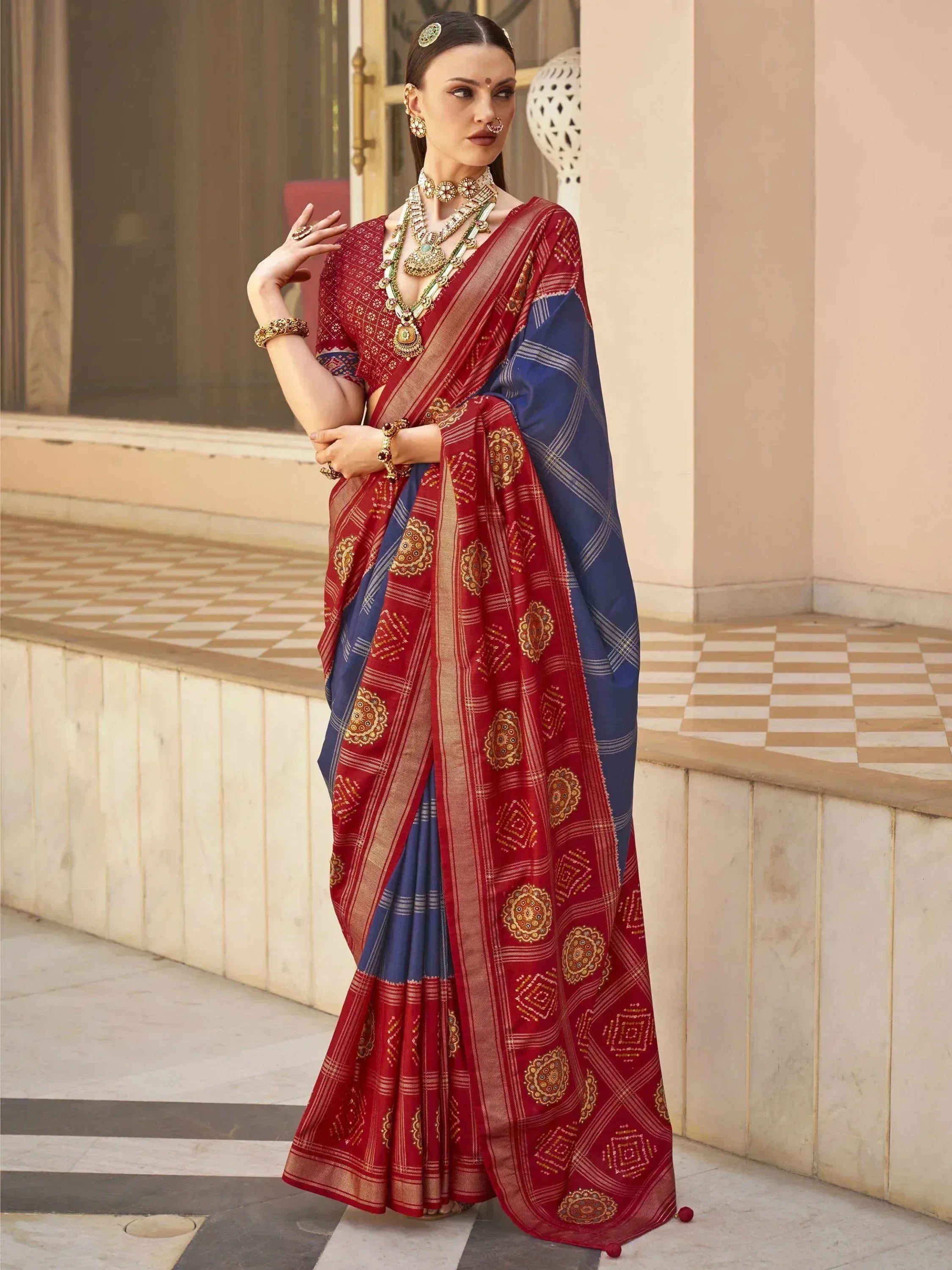 Red and blue ethnic saree with gold embroidery, perfect for Indian weddings and festive occasions.