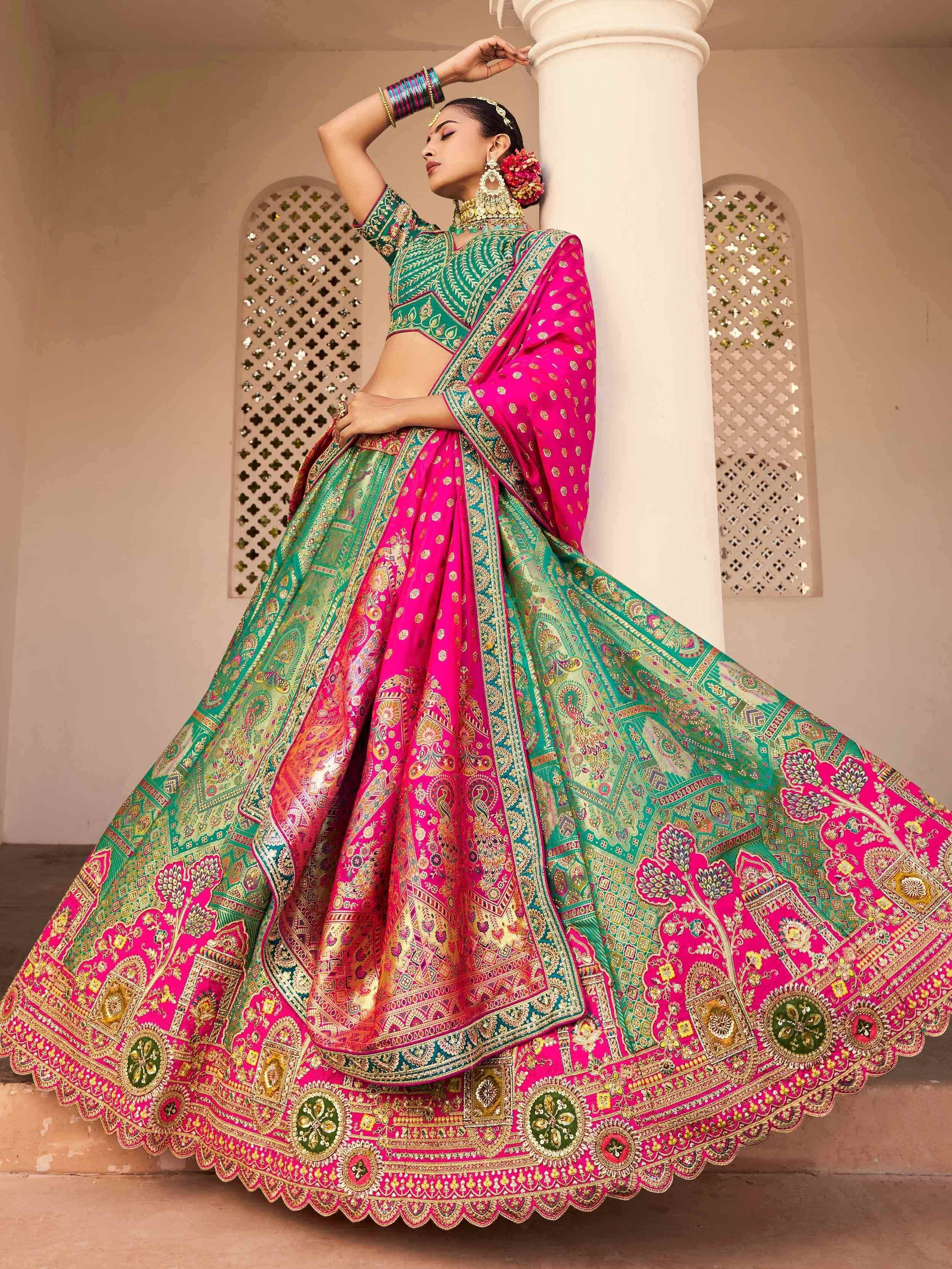 Vibrant pink and green designer lehenga choli with intricate embroidery, perfect for Indian weddings and festive occasions.