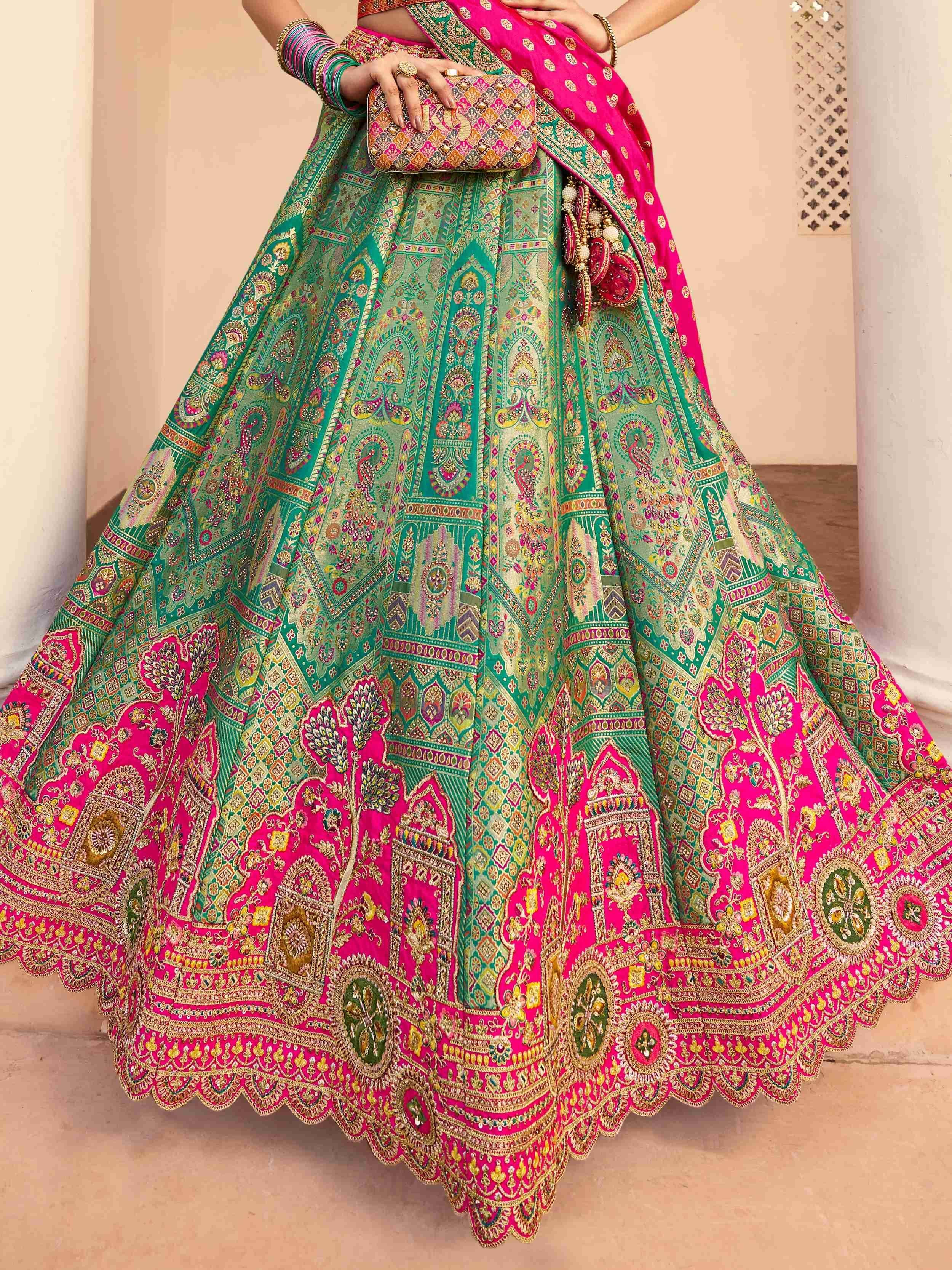 Vibrant green and pink designer lehenga choli with intricate embroidery, perfect for Indian weddings and festive occasions.