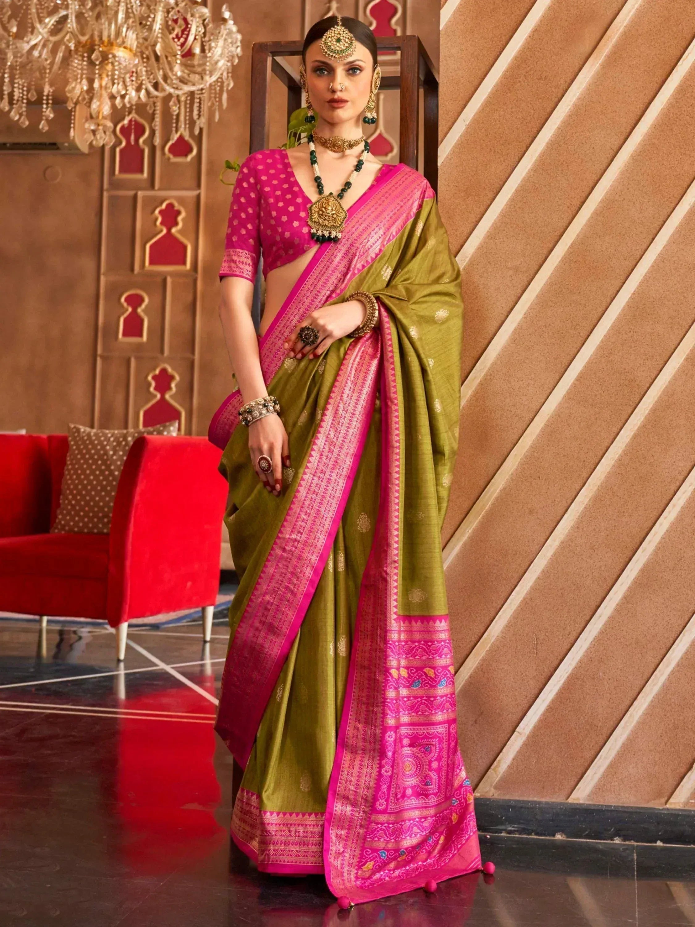 Olive green and pink ethnic saree with intricate border, paired with designer blouse and traditional jewelry