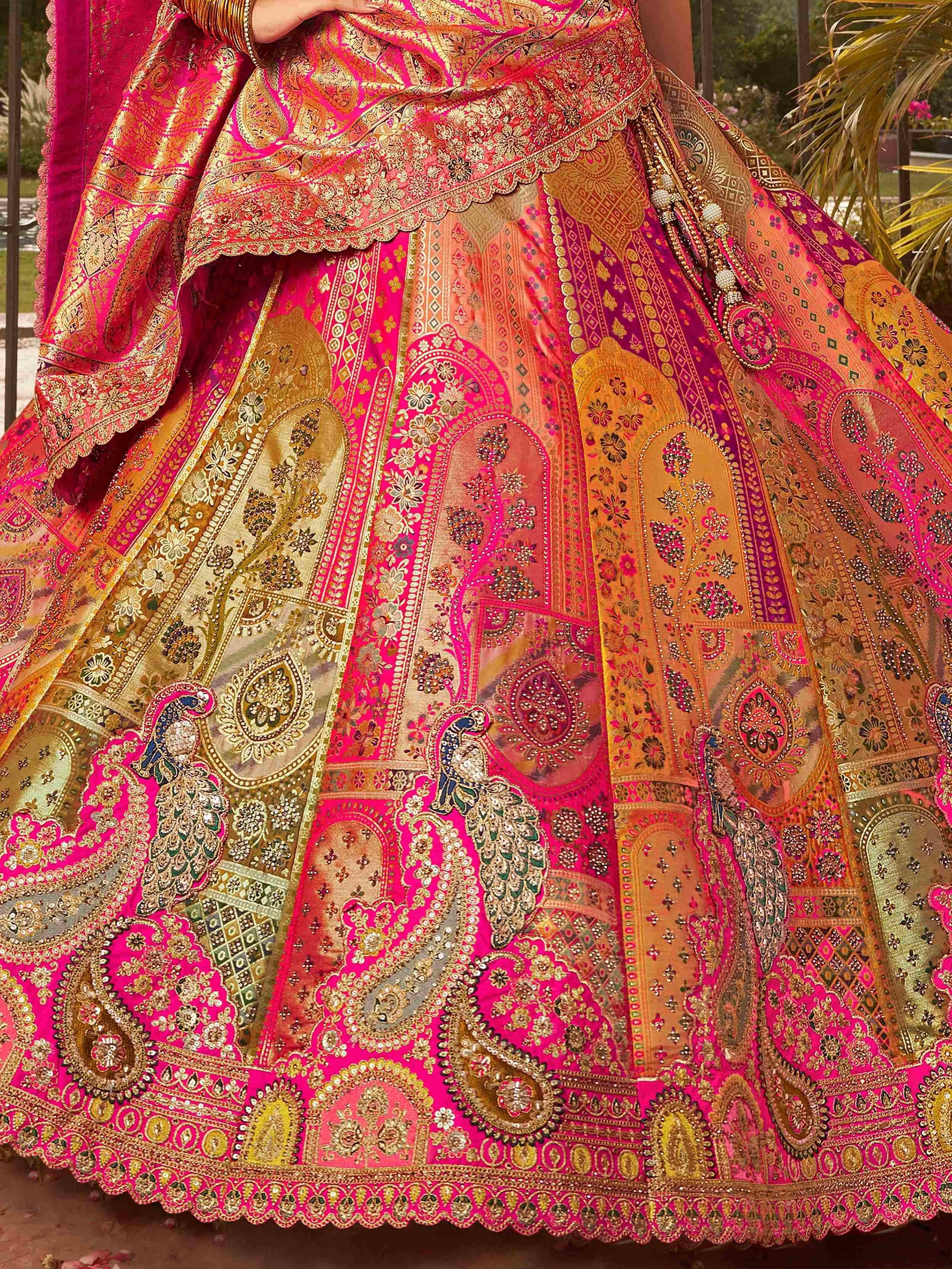 Pink and gold designer lehenga choli with intricate embroidery and peacock motifs, perfect for Indian weddings.