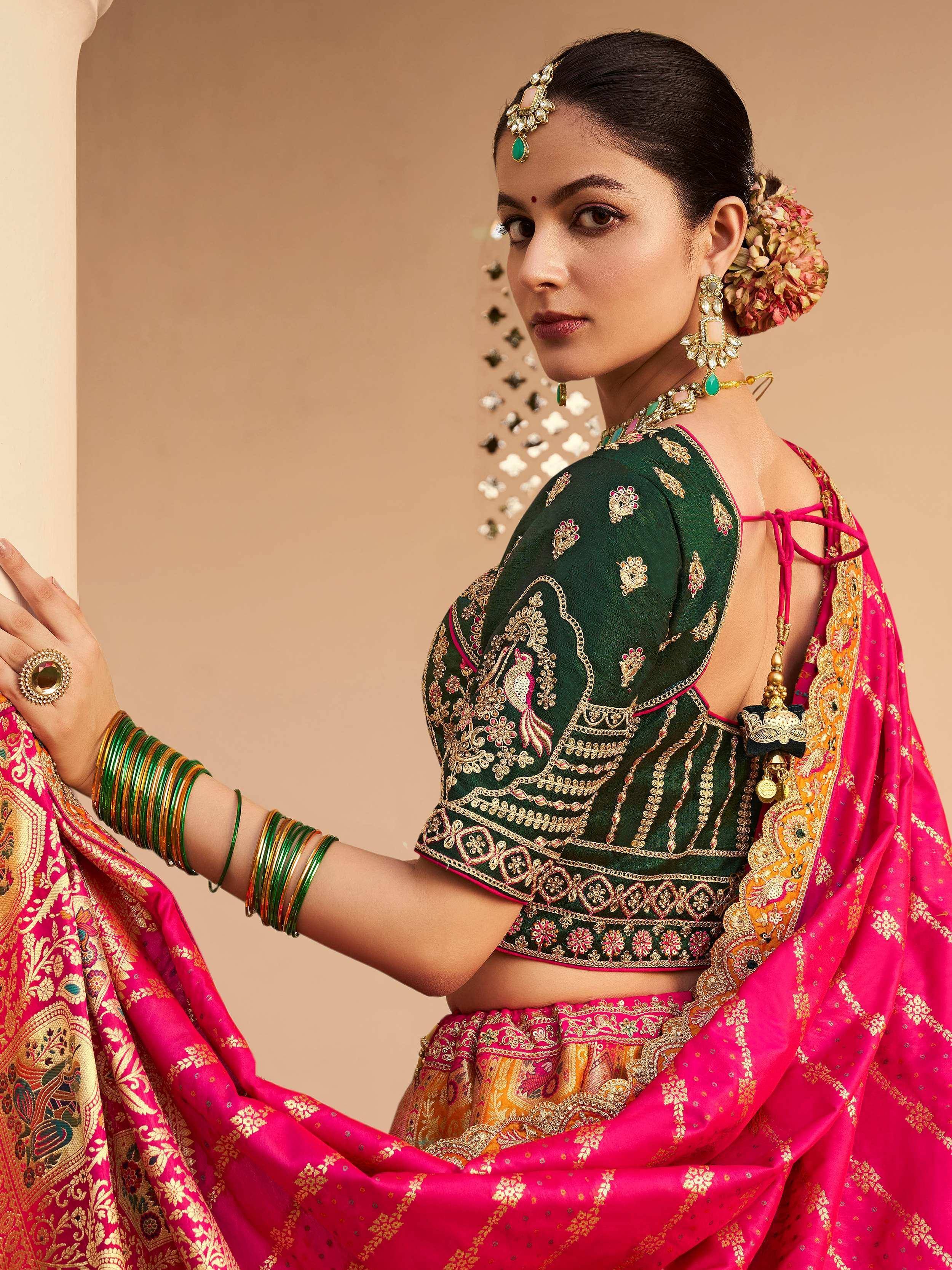 Woman in green embroidered blouse with pink lehenga, traditional Indian ethnic wear, floral hair accessory, gold jewelry