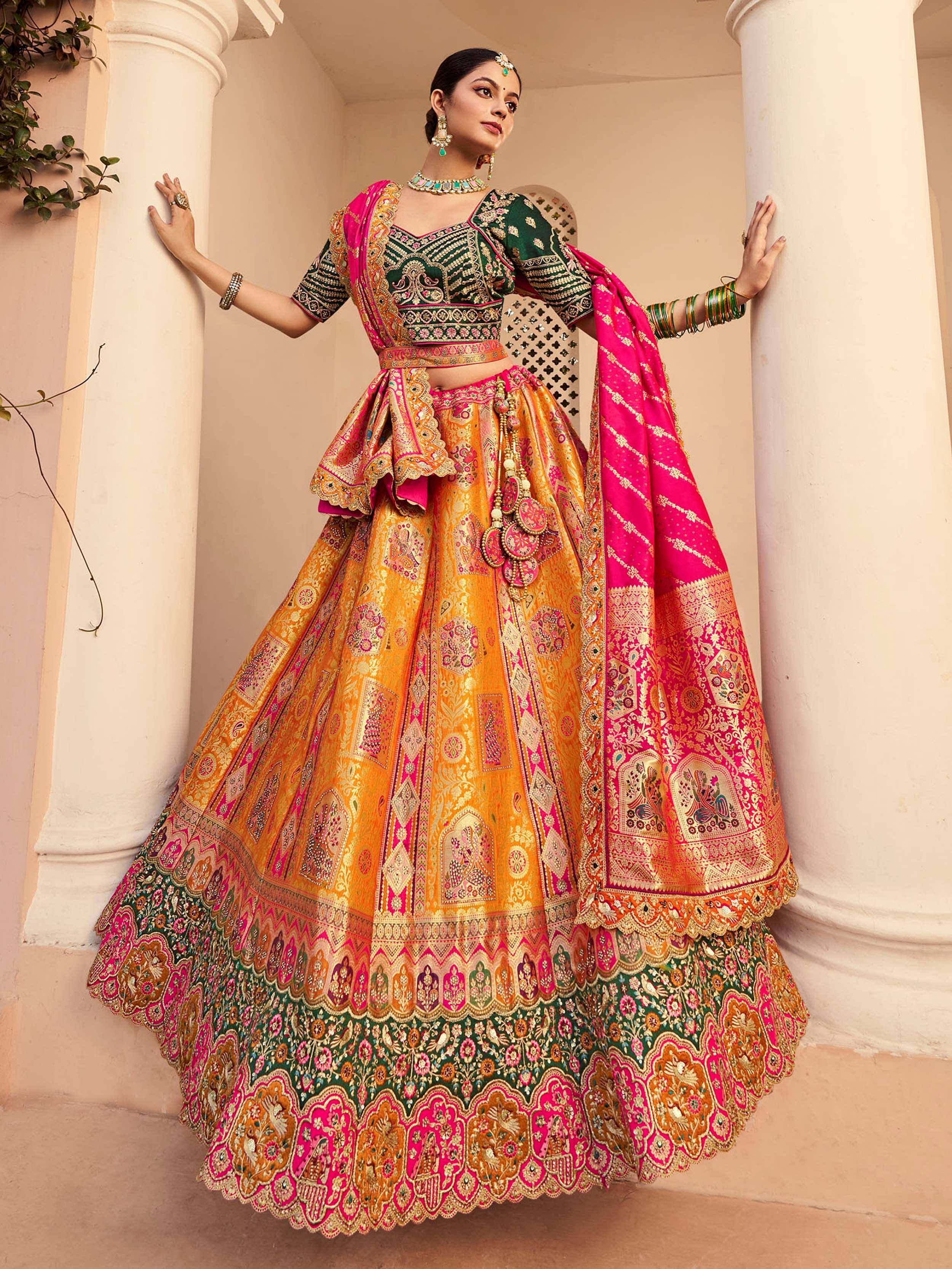 Designer lehenga choli with vibrant pink, green, and gold embroidery, perfect for Indian weddings and festive occasions.